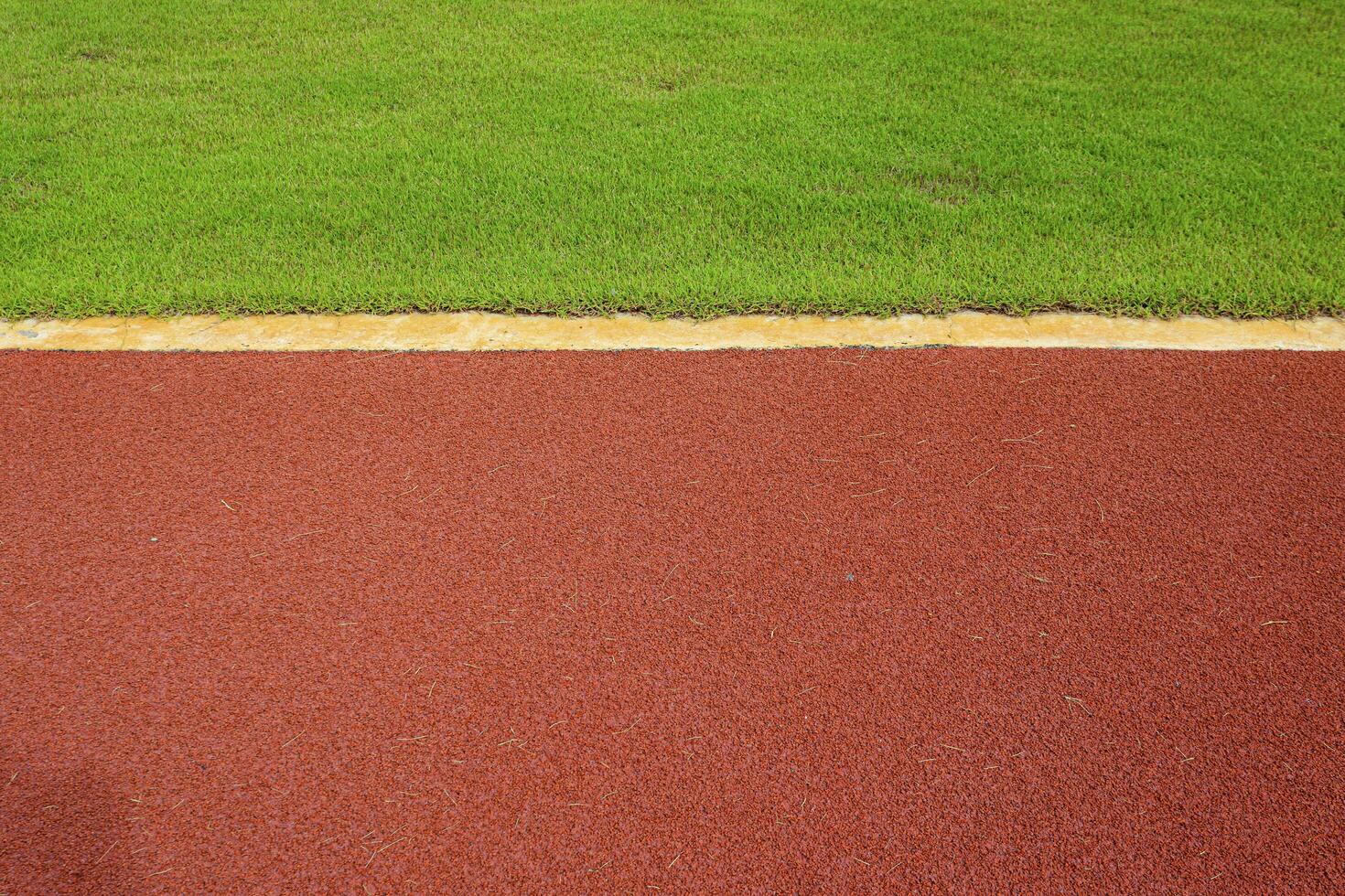 texture of running racetrack red rubber racetracks in outdoor stadium are 8 track and green grass field,empty athletics stadium with track,football field, soccer field. photo