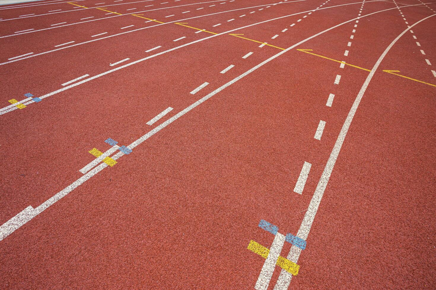 White lines of stadium and texture of running racetrack red rubber racetracks in outdoor stadium are 8 track and green grass field,empty athletics stadium with track. photo