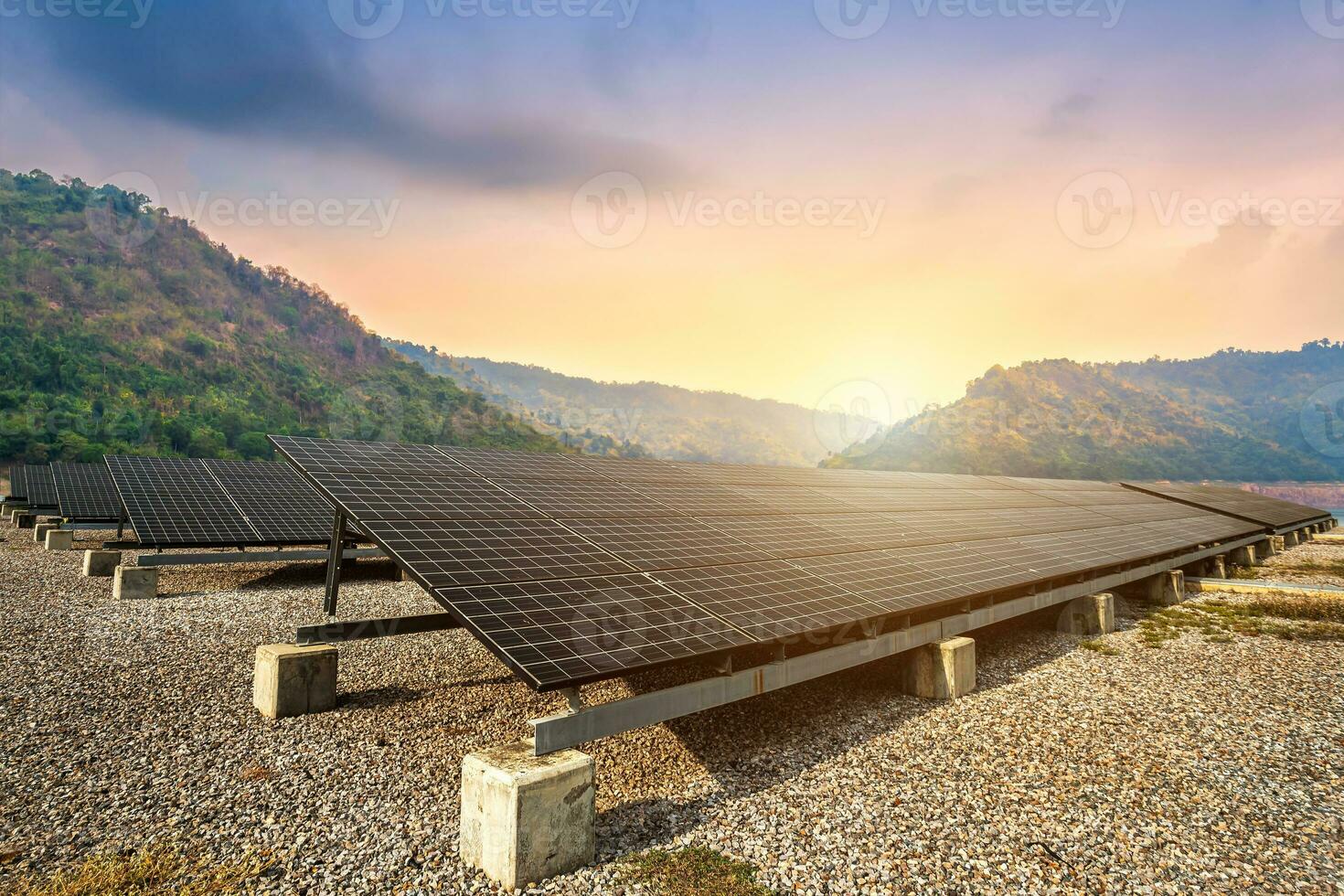 solar paneles con en contra ver de el reservorio y montañas paisaje en contra durante cielo puesta de sol, alternativa energía concepto. foto