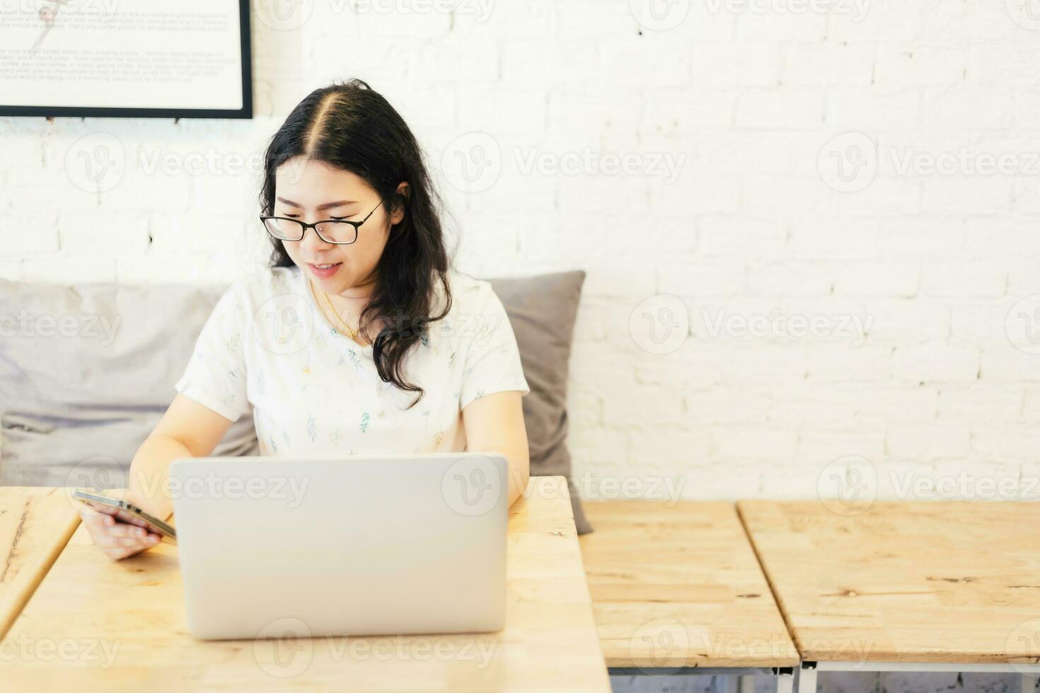 negocio asiático mujer trabajando con teléfono inteligente y ordenador portátil computadora en en café tienda me gusta el antecedentes. foto