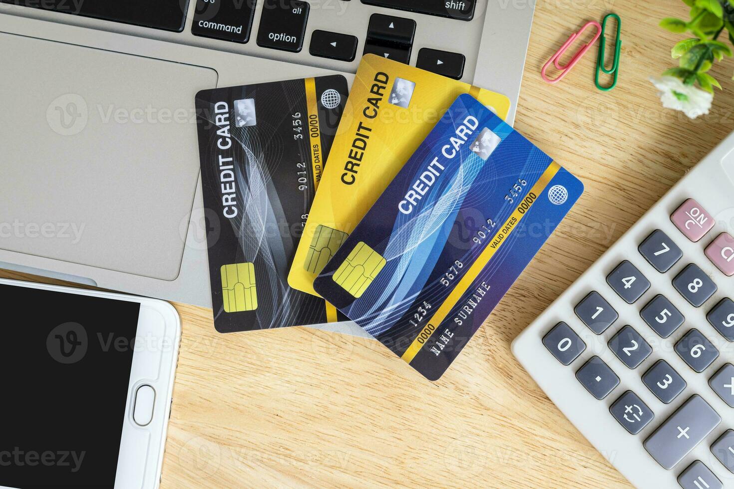 Credit card in Shopping cart with laptop,notebook,flower pot tree,smartphone and calculator on wooden background, Online banking Concept,Top view office table. photo