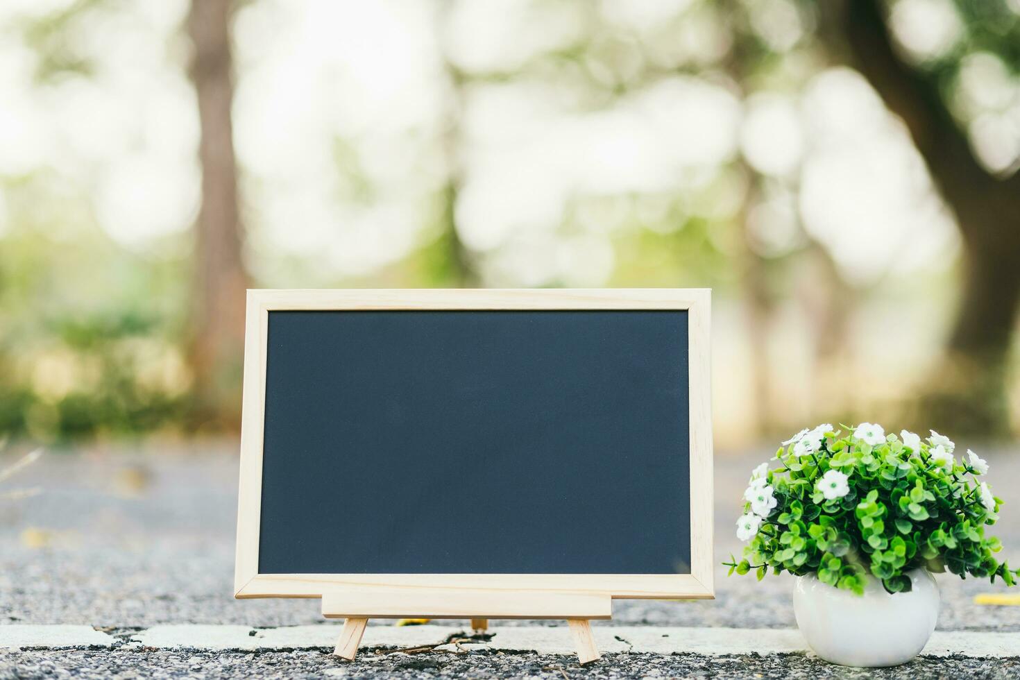 empty wooden blackboard and sphalt road texture in square shape on Road surface in the park background. photo