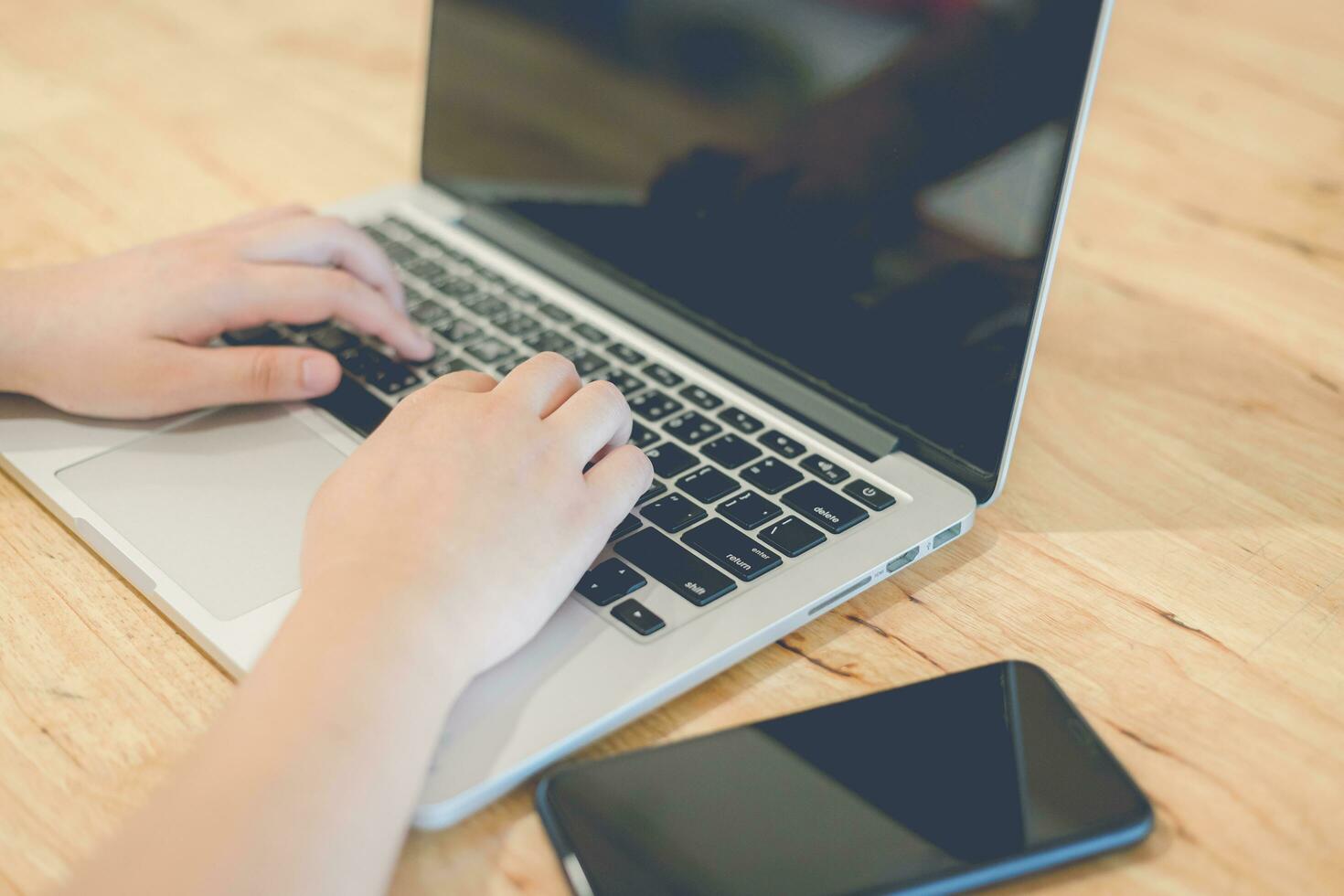 Close-up of business female working with laptop and smartphone in coffee shop like the background photo