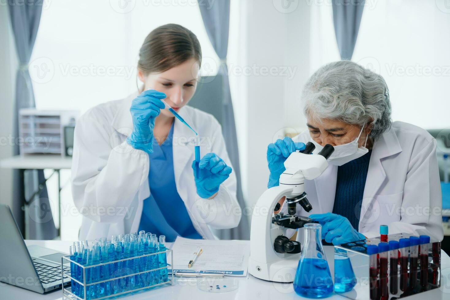 team Female scientist researcher conducting an experiment working in the chemical laboratory photo