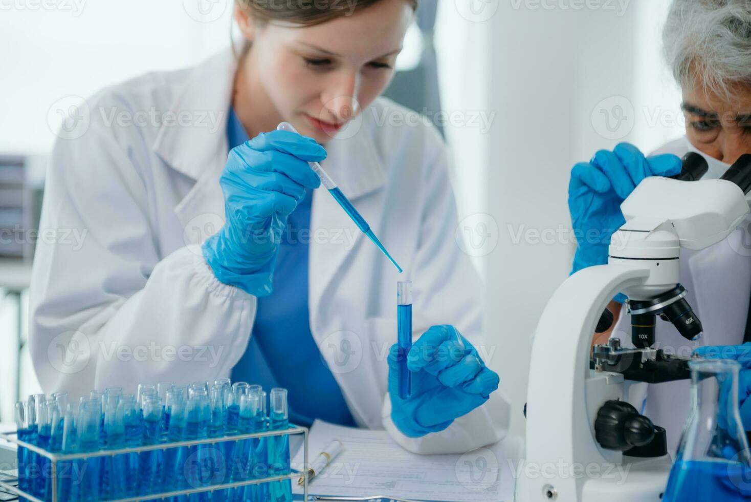 team Female scientist researcher conducting an experiment working in the chemical laboratory photo