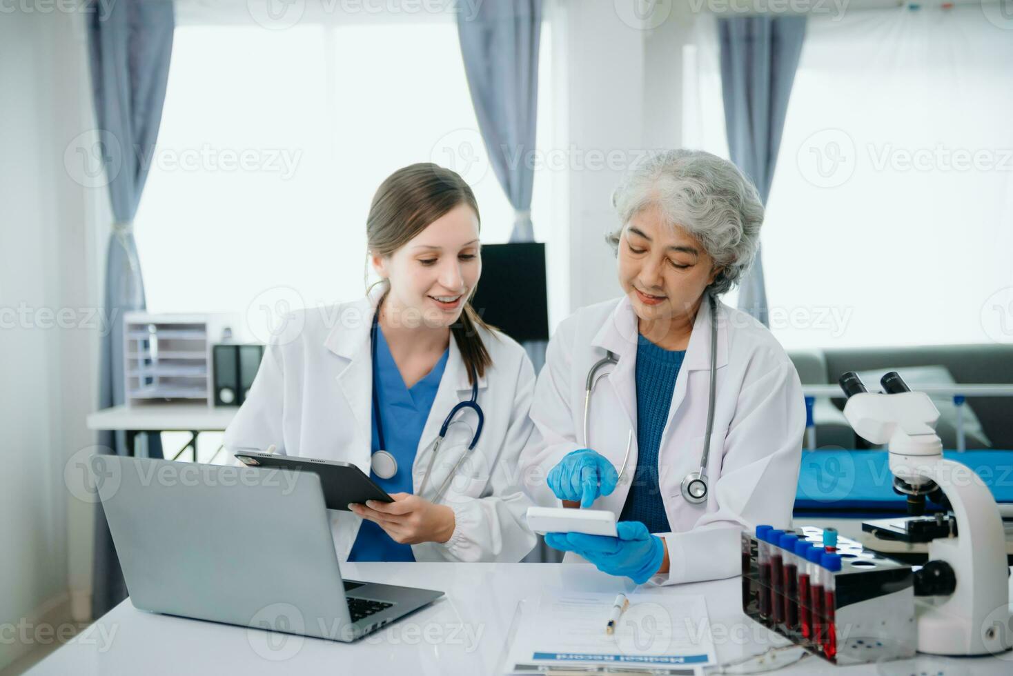 Hospital Ward. Doctor Talks With Professional Head Nurse or Surgeon, They Use Digital tablet Computer. Diverse Team of Health Care Specialists Discussing Test Result photo