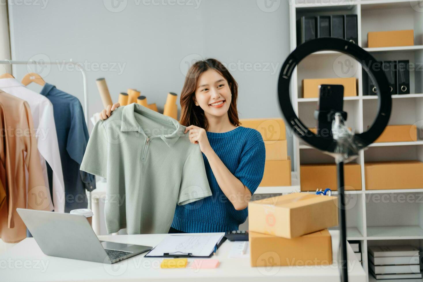 Young woman running online store Startup small business SME, using smartphone or tablet taking receive and checking online purchase shopping photo