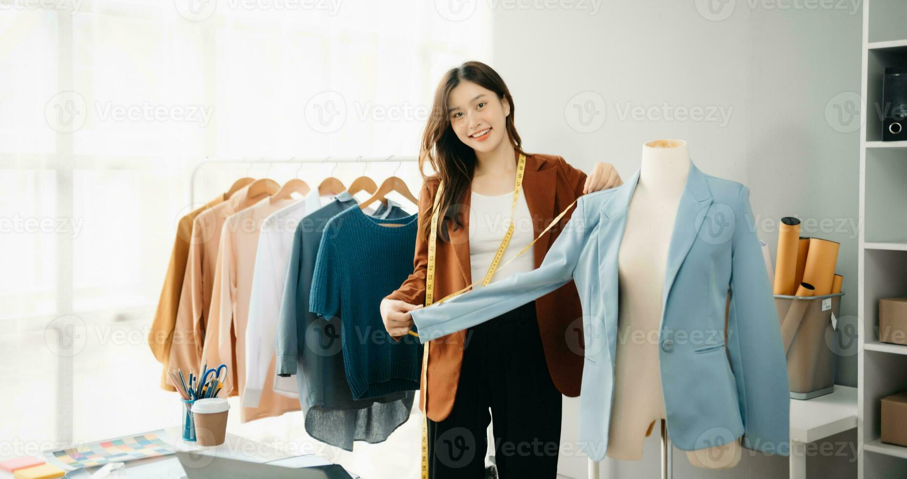 Diverse female fashion designers at work with tailor centimeters on necks and holds tablet and smartphone. independent creative design photo