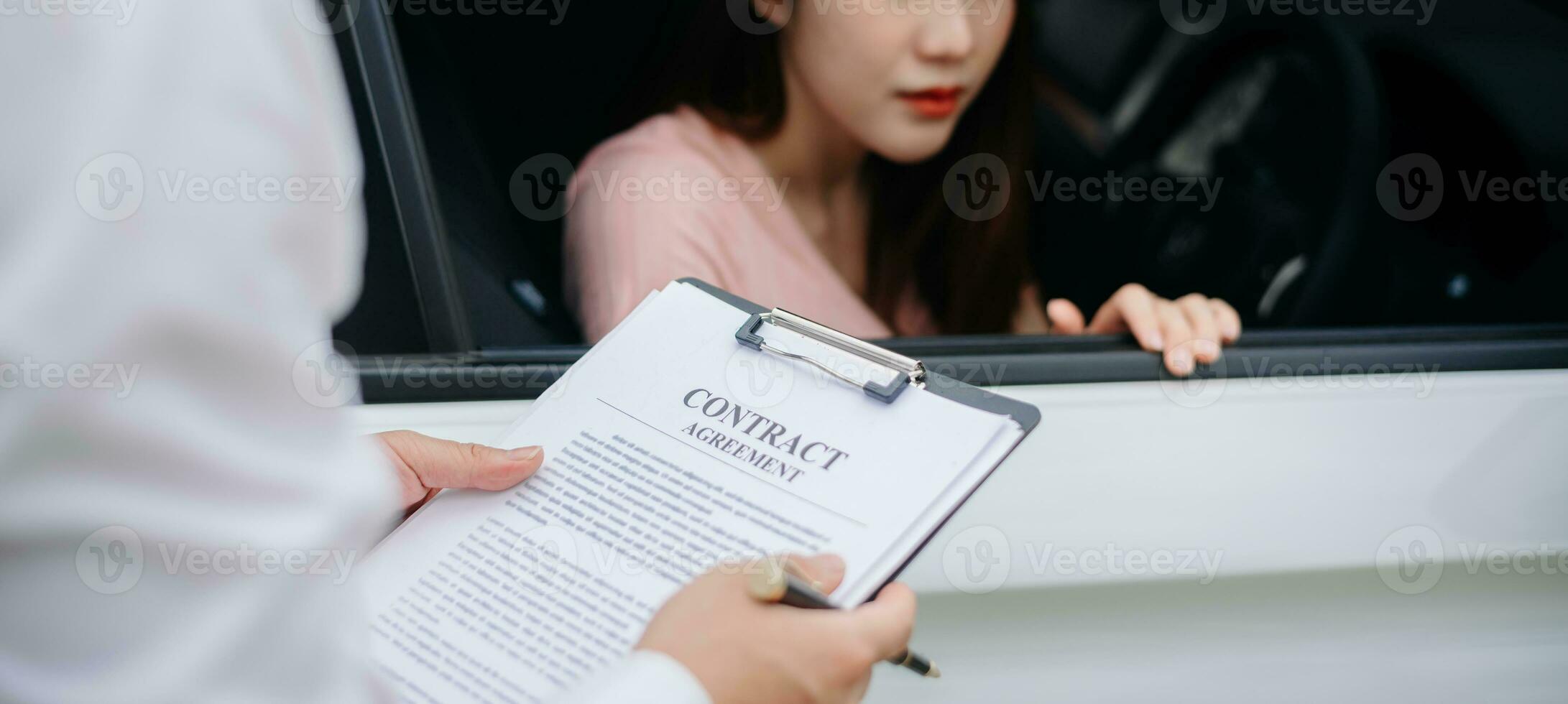 Automotive business, car sale or rental concept Customer with car dealer agent making deal and signing on agreement document contract in auto showroom or on road photo