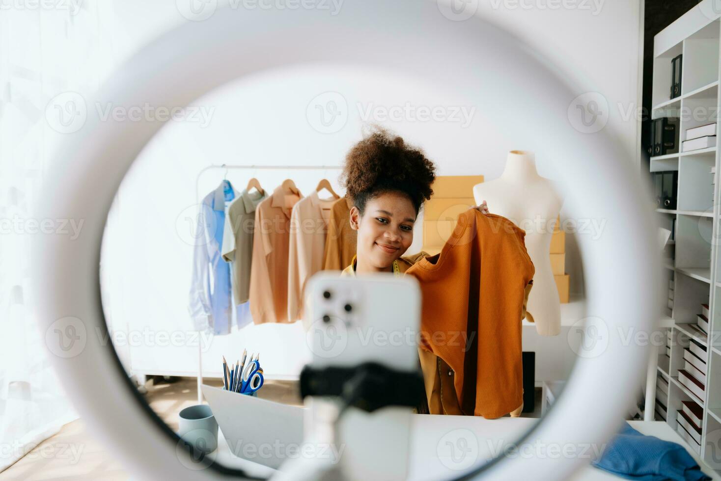 Fashion blogger concept, Young African women selling clothes on video streaming.Startup small business SME, using smartphone or tablet photo
