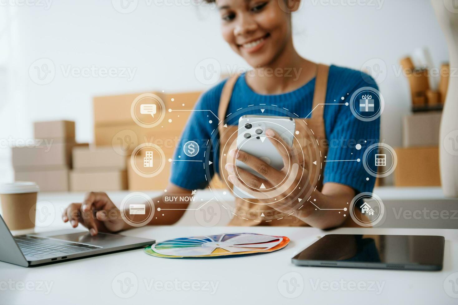 Young woman holding a smartphone, tablet showing payment success and credit card with yellow parcel box as online shopping concept photo