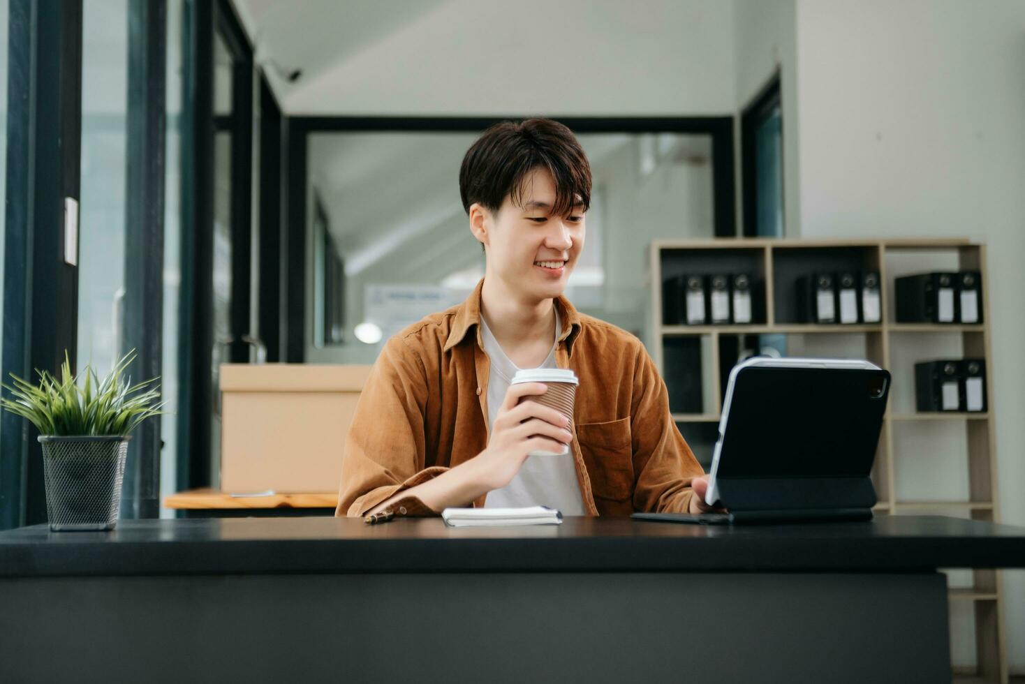 Portrait of a young man sitting at his desk in the office. photo