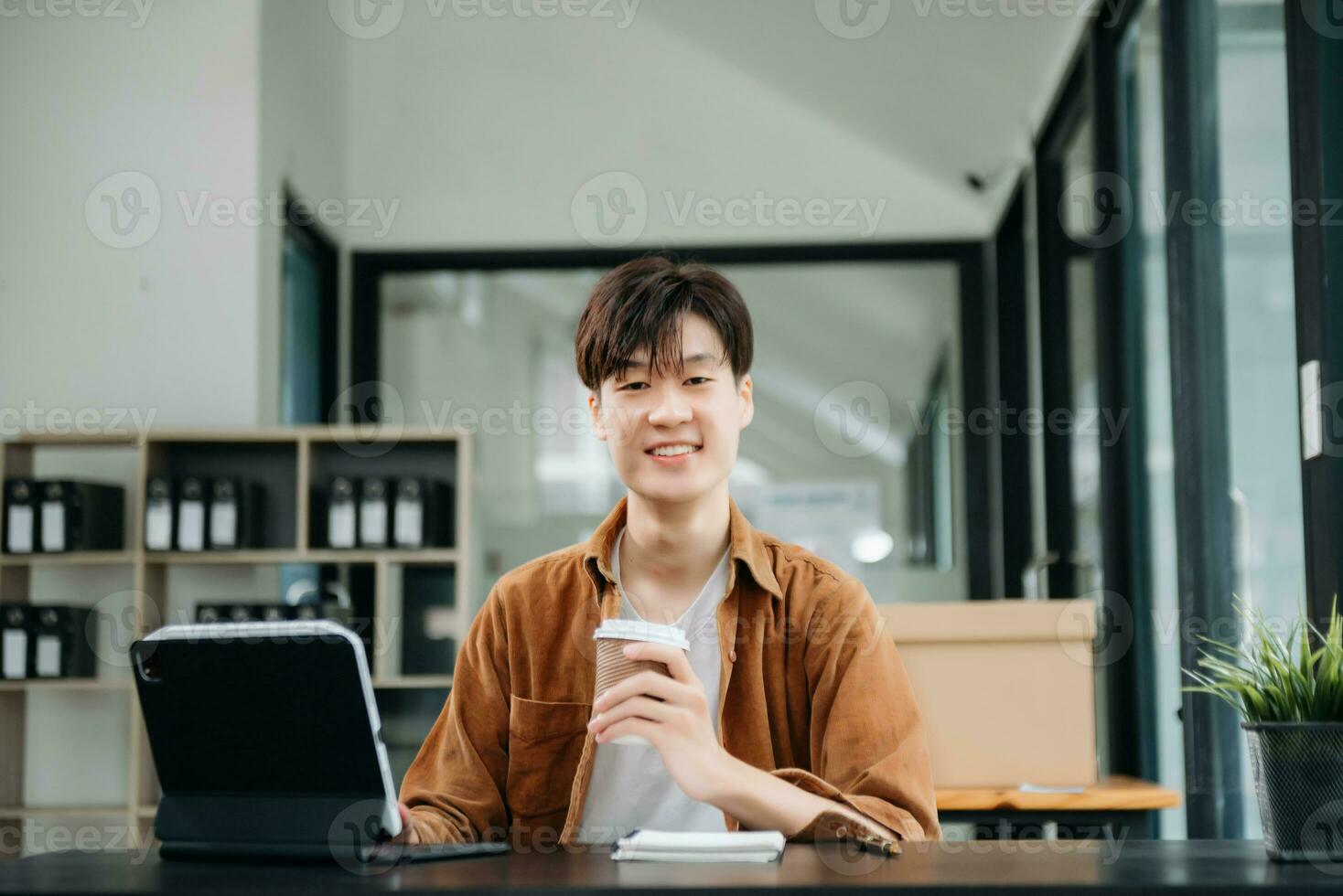 Portrait of a young man sitting at his desk in the office. photo