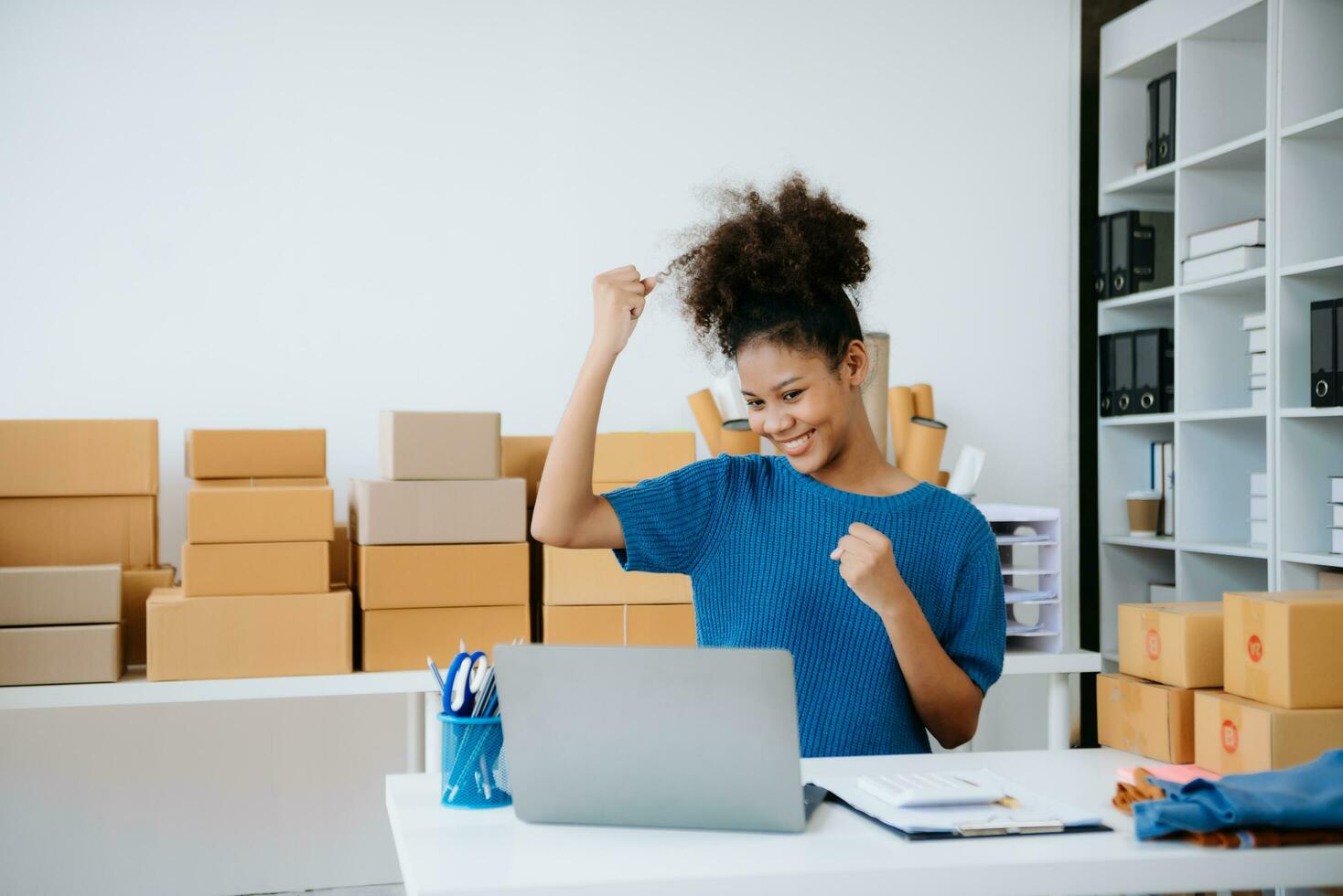 Young woman running online store Startup small business SME, using smartphone or tablet taking receive and checking online purchase shopping order photo