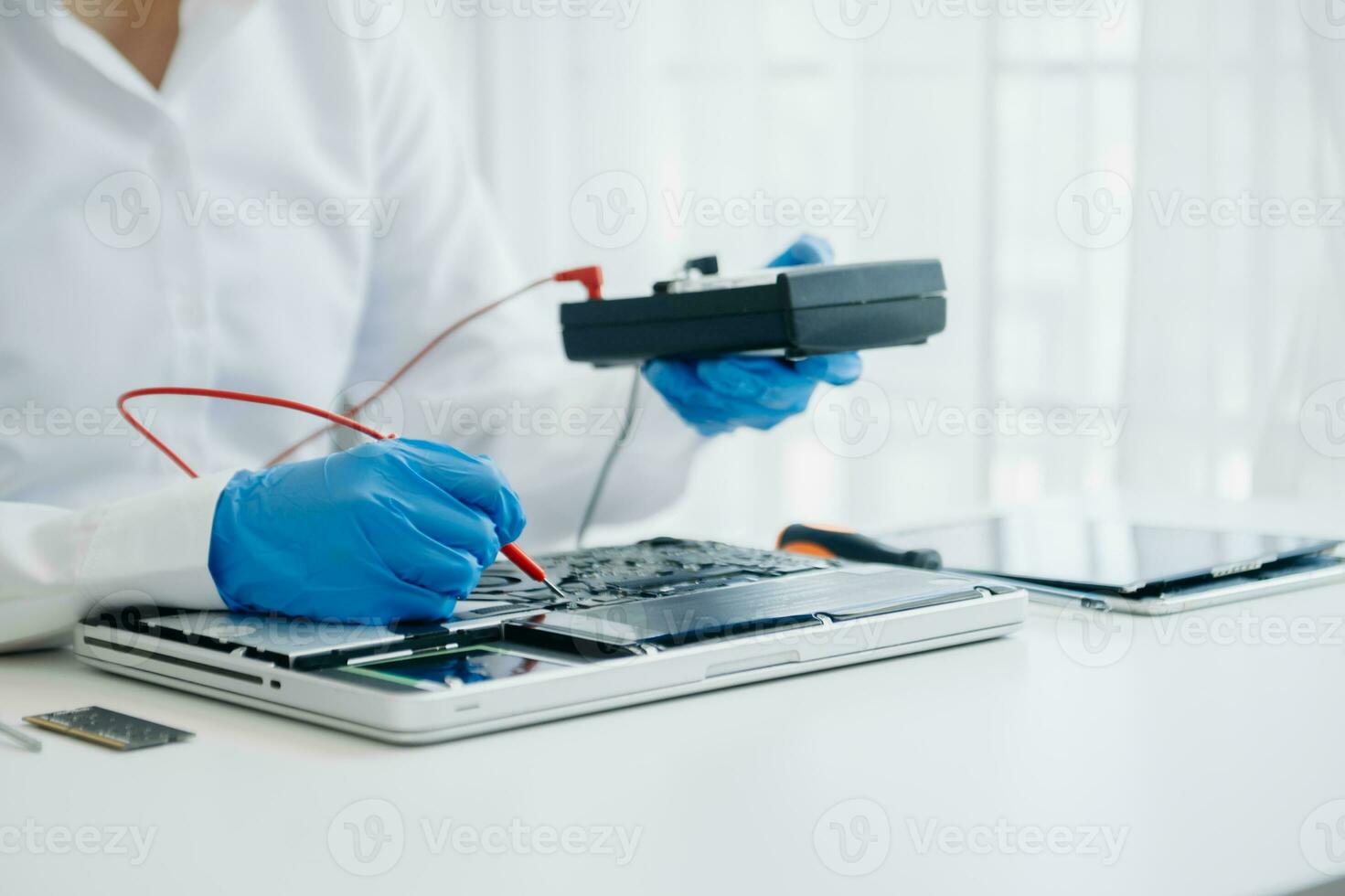 Electronics technician, electronic engineering electronic repair,electronics measuring and testing, repair and maintenance concepts.uses a voltage meter to check and upgrade in shop photo