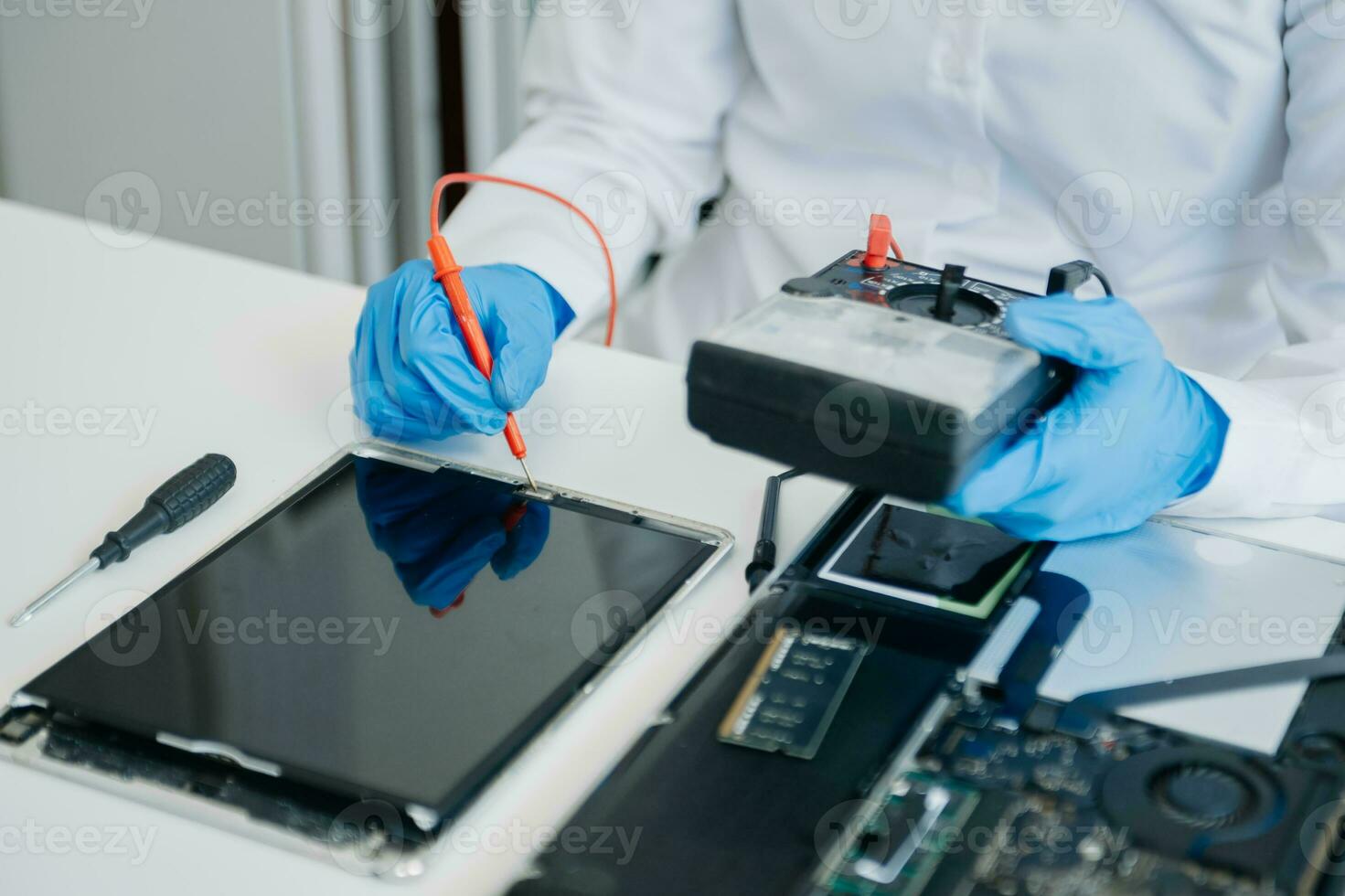 Electronics technician, electronic engineering electronic repair,electronics measuring and testing, repair and maintenance concepts.uses a voltage meter to check and upgrade in shop photo