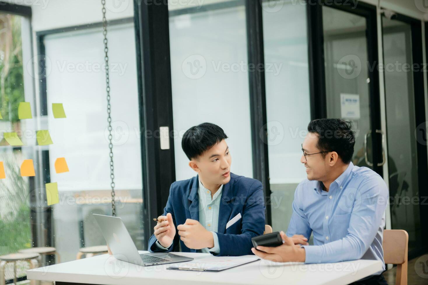 Male discussing new project with business colleague. Young man talking with young man in office. photo