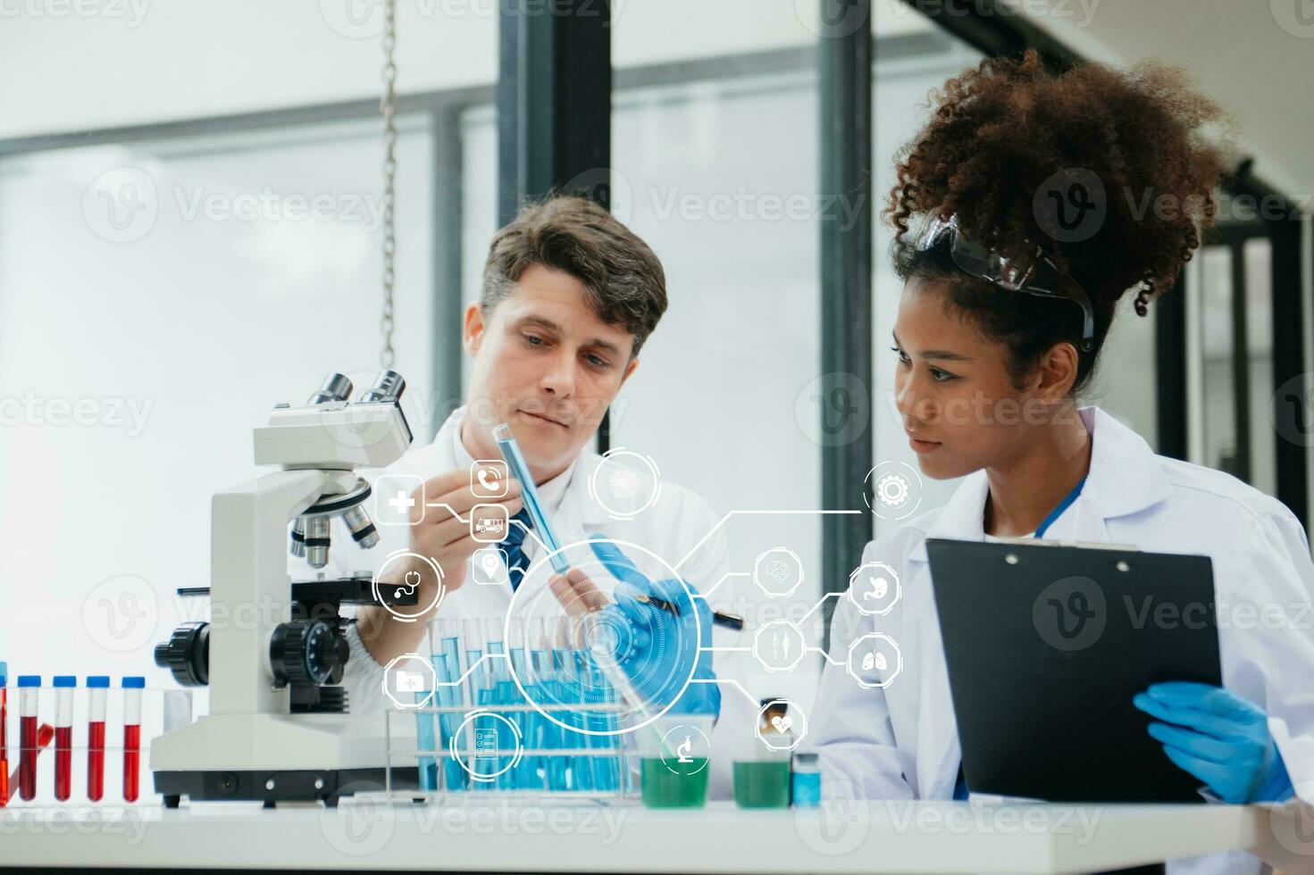 Mature scientists conducting research investigations in a medical laboratory, a researcher in the foreground is using a microscope in laboratory for medicine. photo