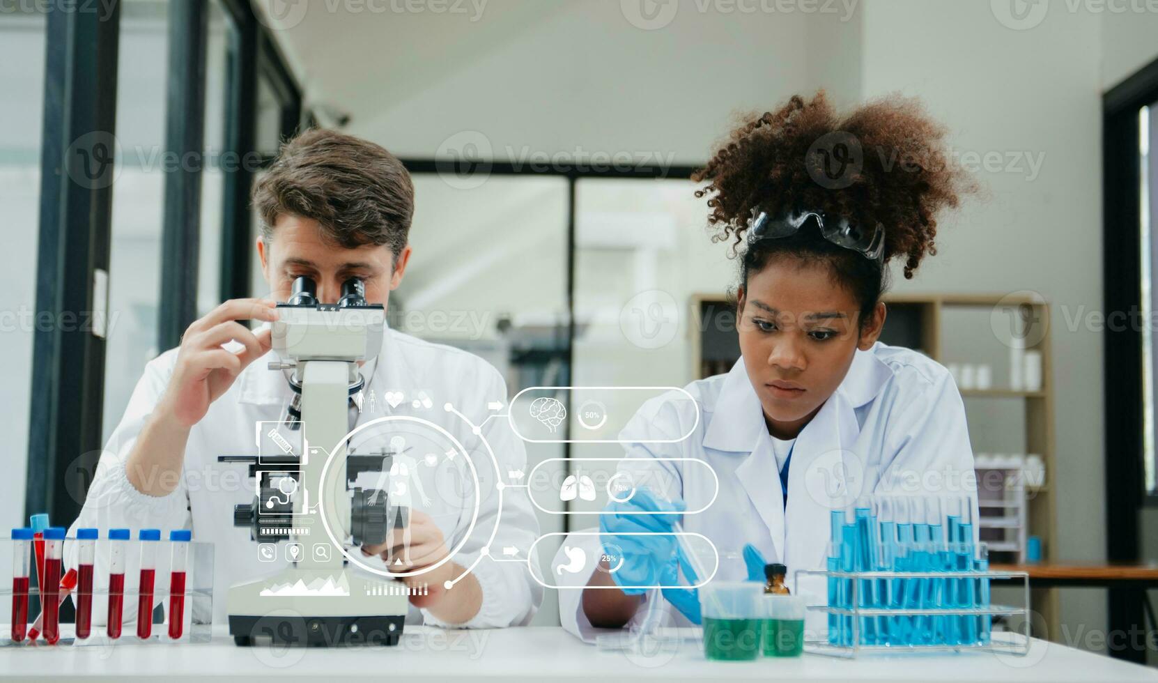 Mature scientists conducting research investigations in a medical laboratory, a researcher in the foreground is using a microscope in laboratory for medicine. photo