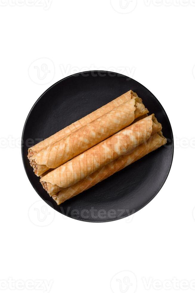 Delicious crispy wafer rolls with cream filling with nuts photo