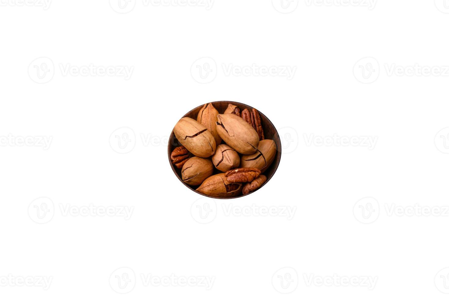 Pecan nuts in shell and peeled in a wooden round bowl photo