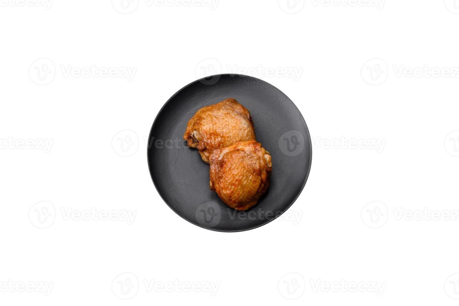 delicioso jugoso pollo muslos horneado con sal, especias y hierbas en un cerámico plato foto