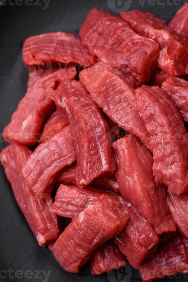 crudo orgánico carne carne de vaca o Cordero cortar dentro rebanadas con sal, especias y hierbas foto