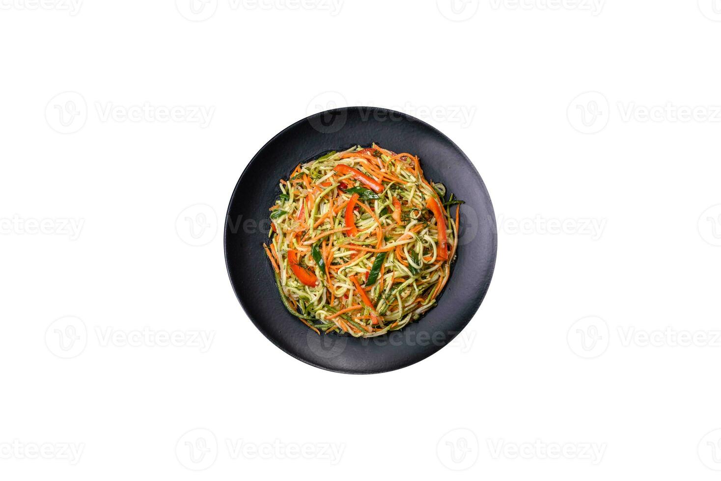 Fresh salad of sliced thin strips of carrot and zucchini on a concrete background photo