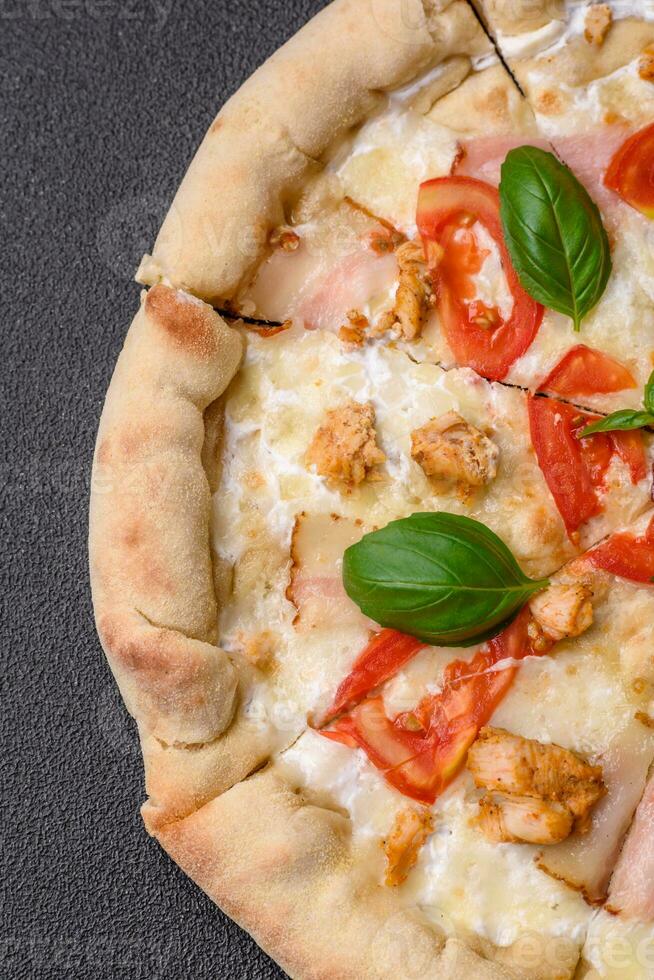 Delicious hot pizza with chicken, tomatoes, cheese and bacon, with salt and spices photo