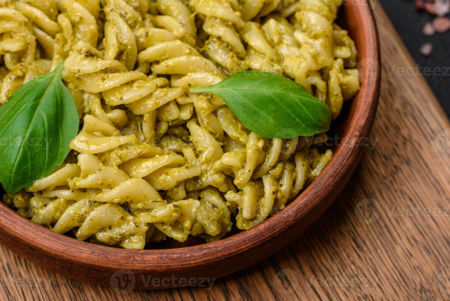 Delicious fresh pasta with green pesto sauce with basil photo