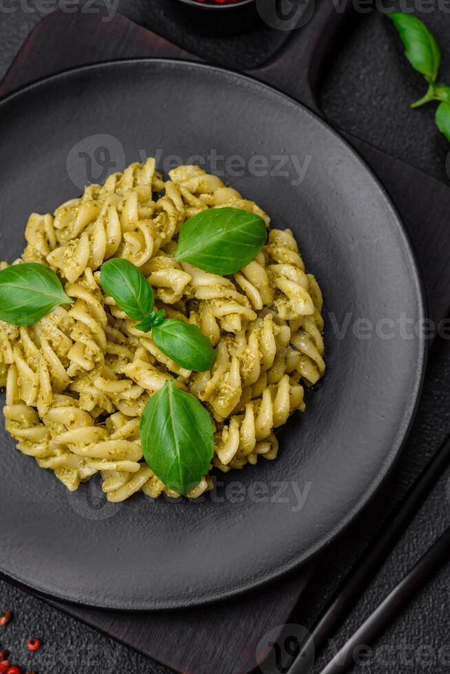 Delicious fresh pasta with green pesto sauce with basil photo