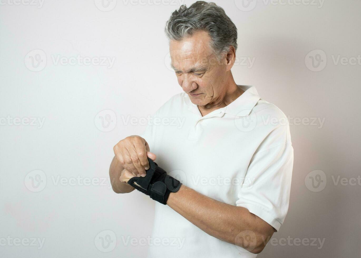 Senior Man wearing a wrist brace on his left hand and wrist for pain management photo