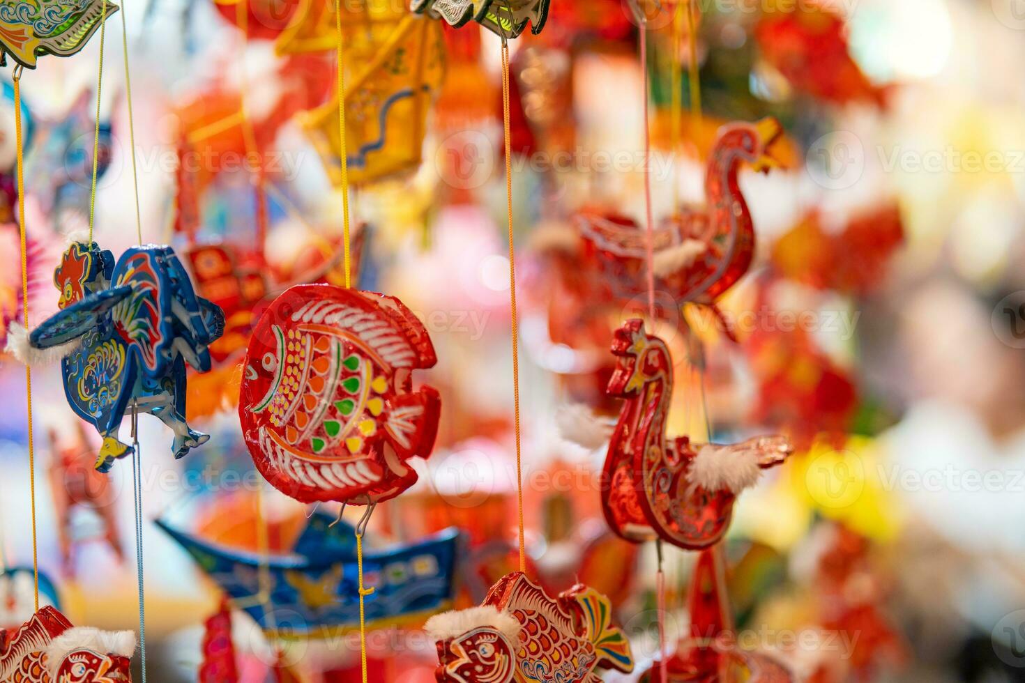 Decorated colorful lanterns hanging on a stand in the streets in Ho Chi Minh City, Vietnam during Mid Autumn Festival. Chinese language in photos mean money and happiness. Selective focus.