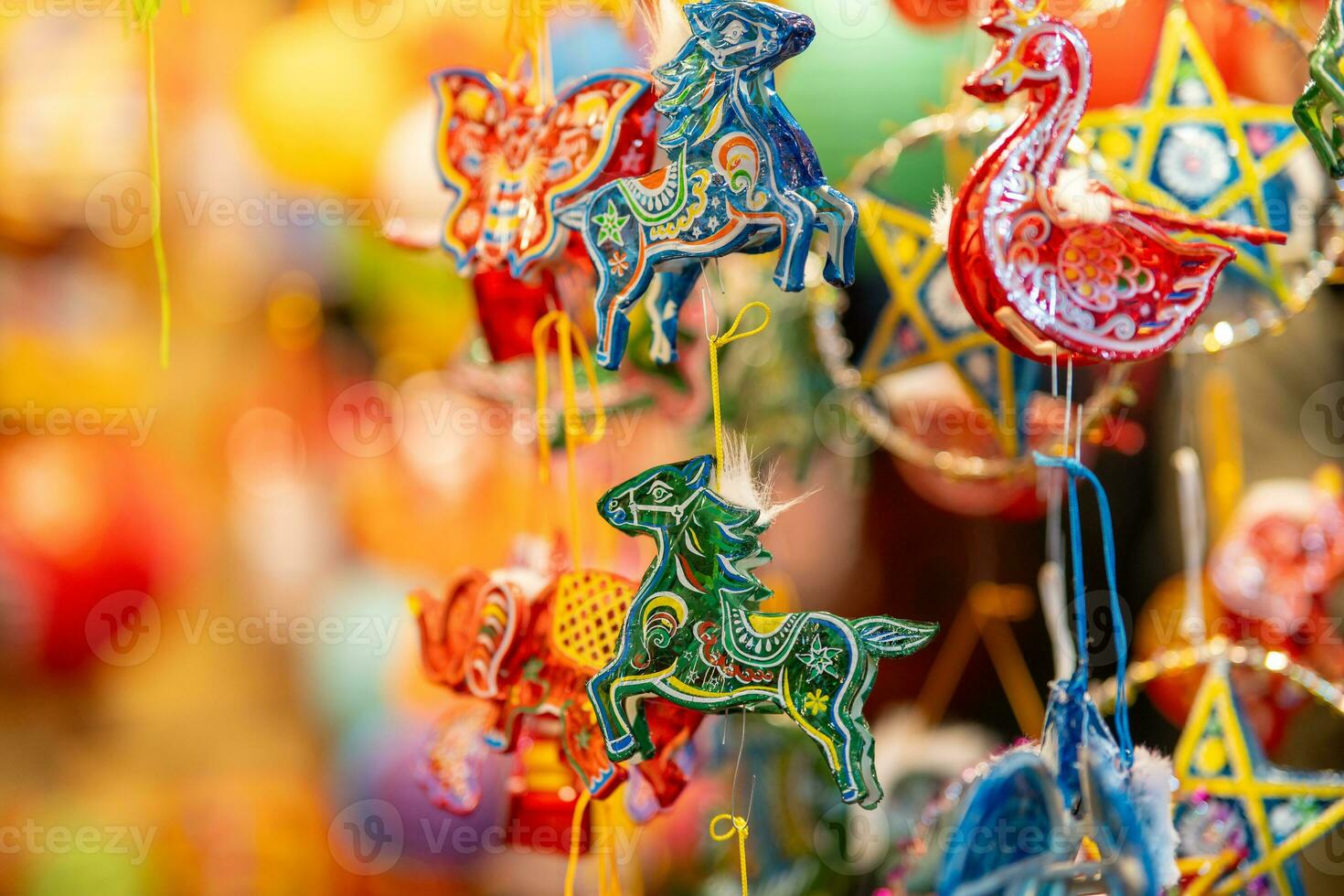 Decorated colorful lanterns hanging on a stand in the streets in Ho Chi Minh City, Vietnam during Mid Autumn Festival. Chinese language in photos mean money and happiness. Selective focus.