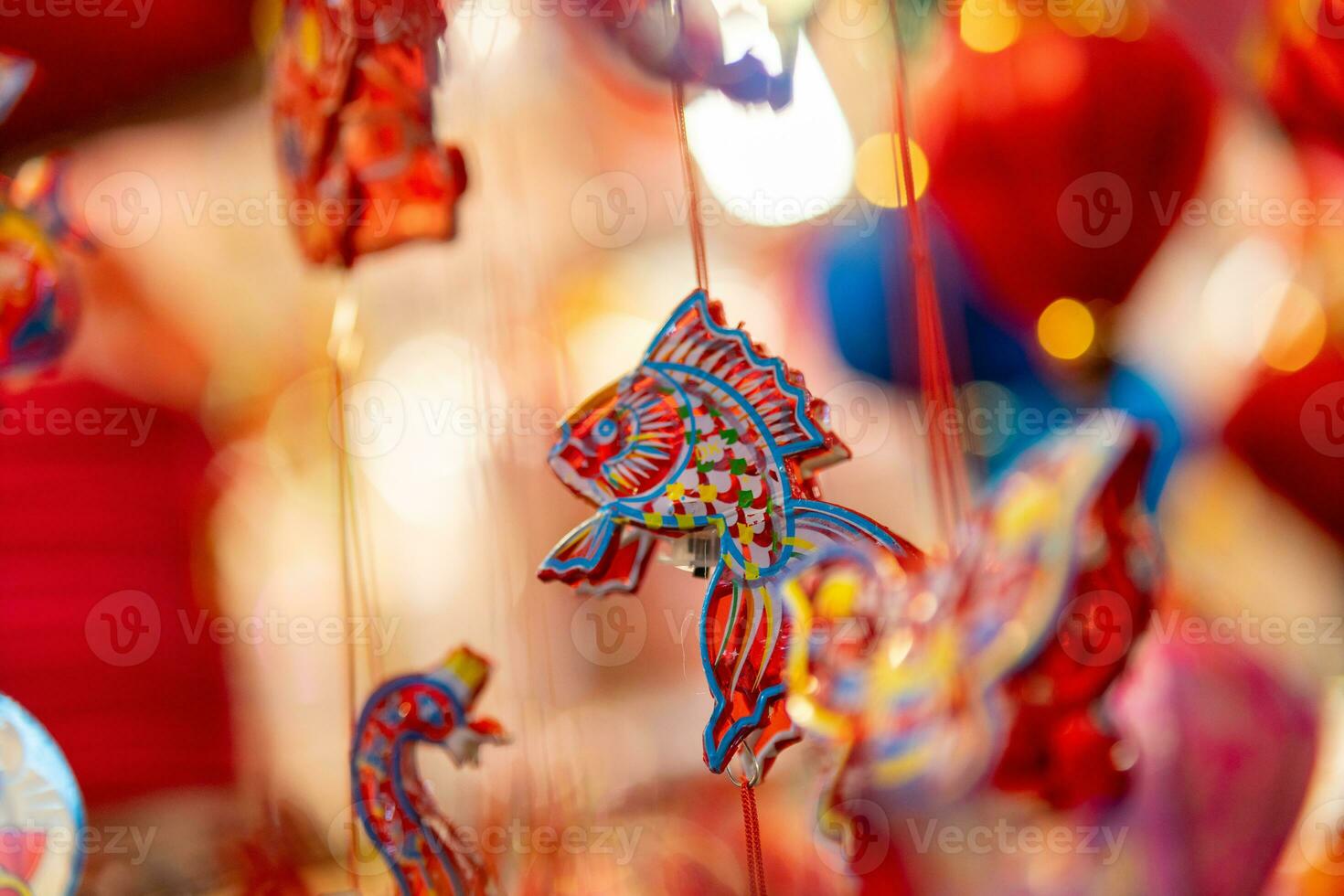 Decorated colorful lanterns hanging on a stand in the streets in Ho Chi Minh City, Vietnam during Mid Autumn Festival. Chinese language in photos mean money and happiness. Selective focus.