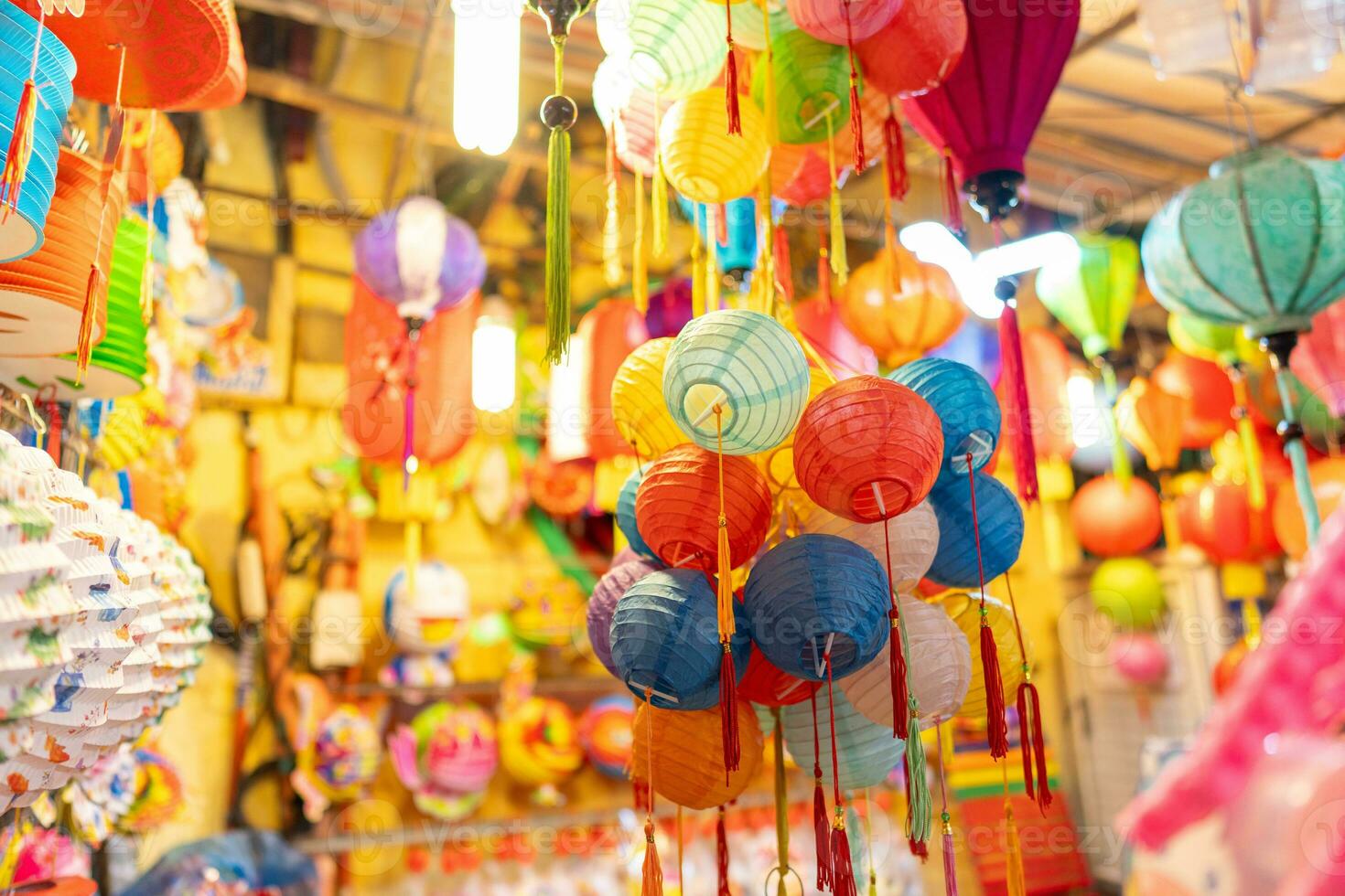 Decorated colorful lanterns hanging on a stand in the streets in Ho Chi Minh City, Vietnam during Mid Autumn Festival. Chinese language in photos mean money and happiness. Selective focus.