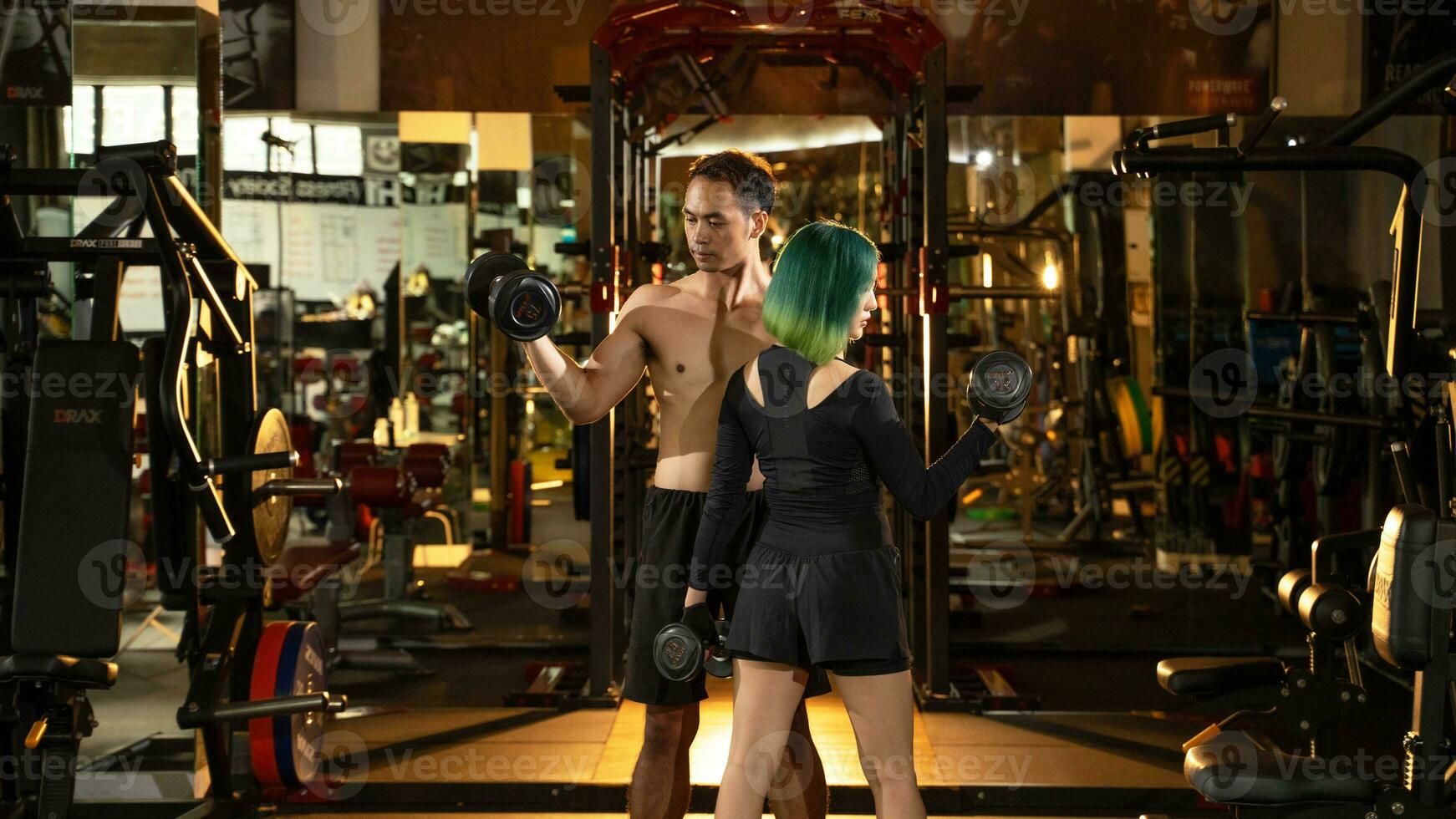 Young man and woman lifting dumbbells. bodybuilding and exercising Concept. photo