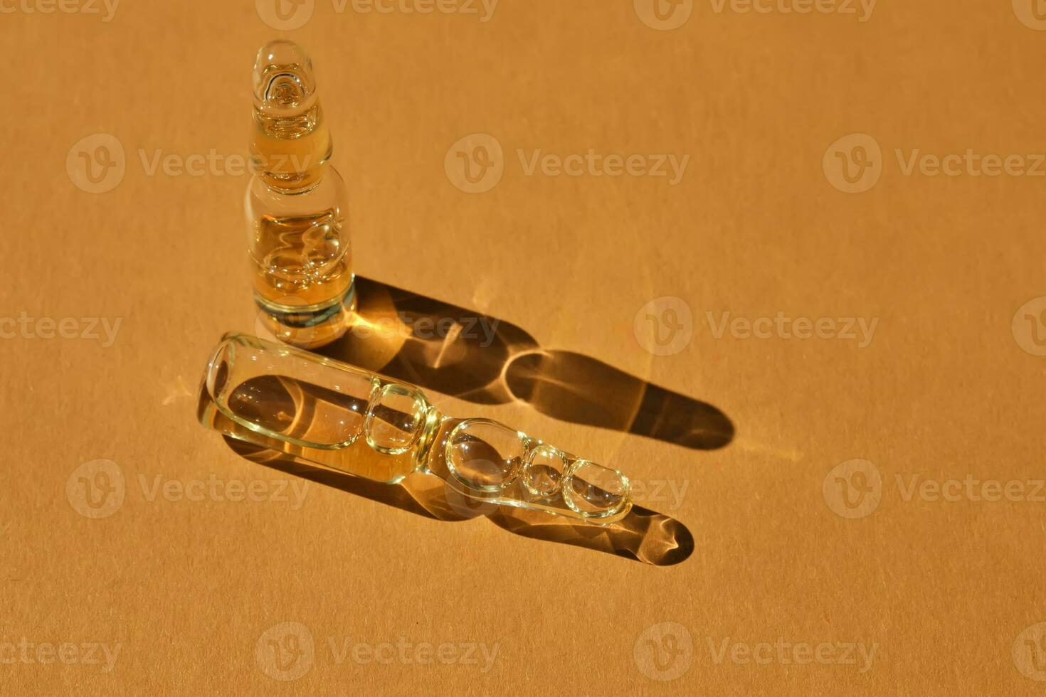 Glass ampoules on a beige orange background. photo