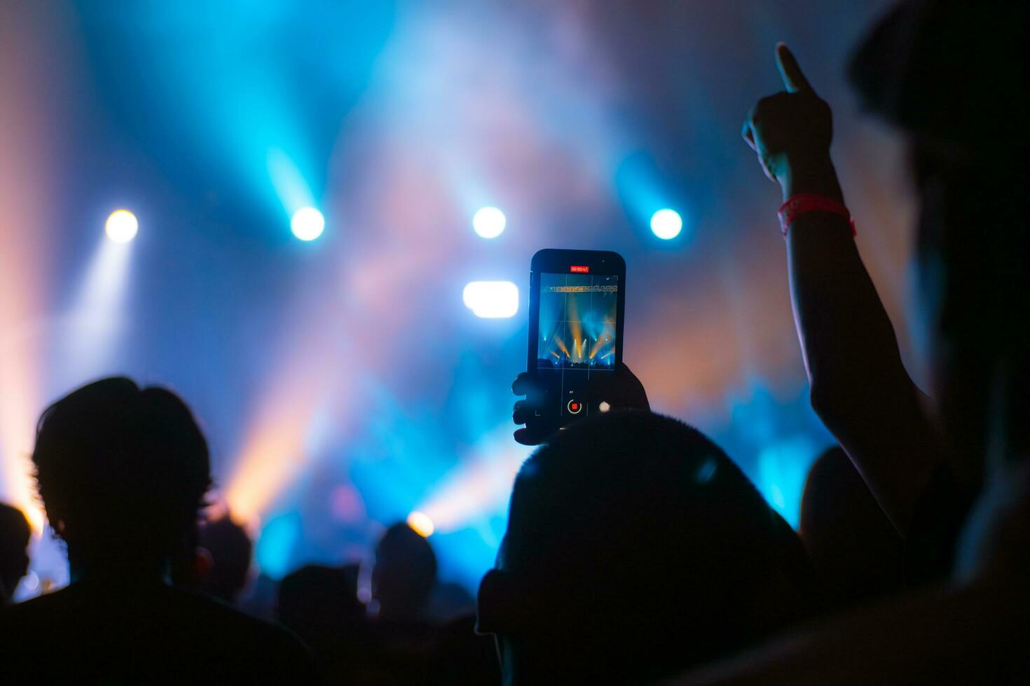 People holding smart phone and recording and photographing in concert , silhouette of hands with mobile , event background concept photo