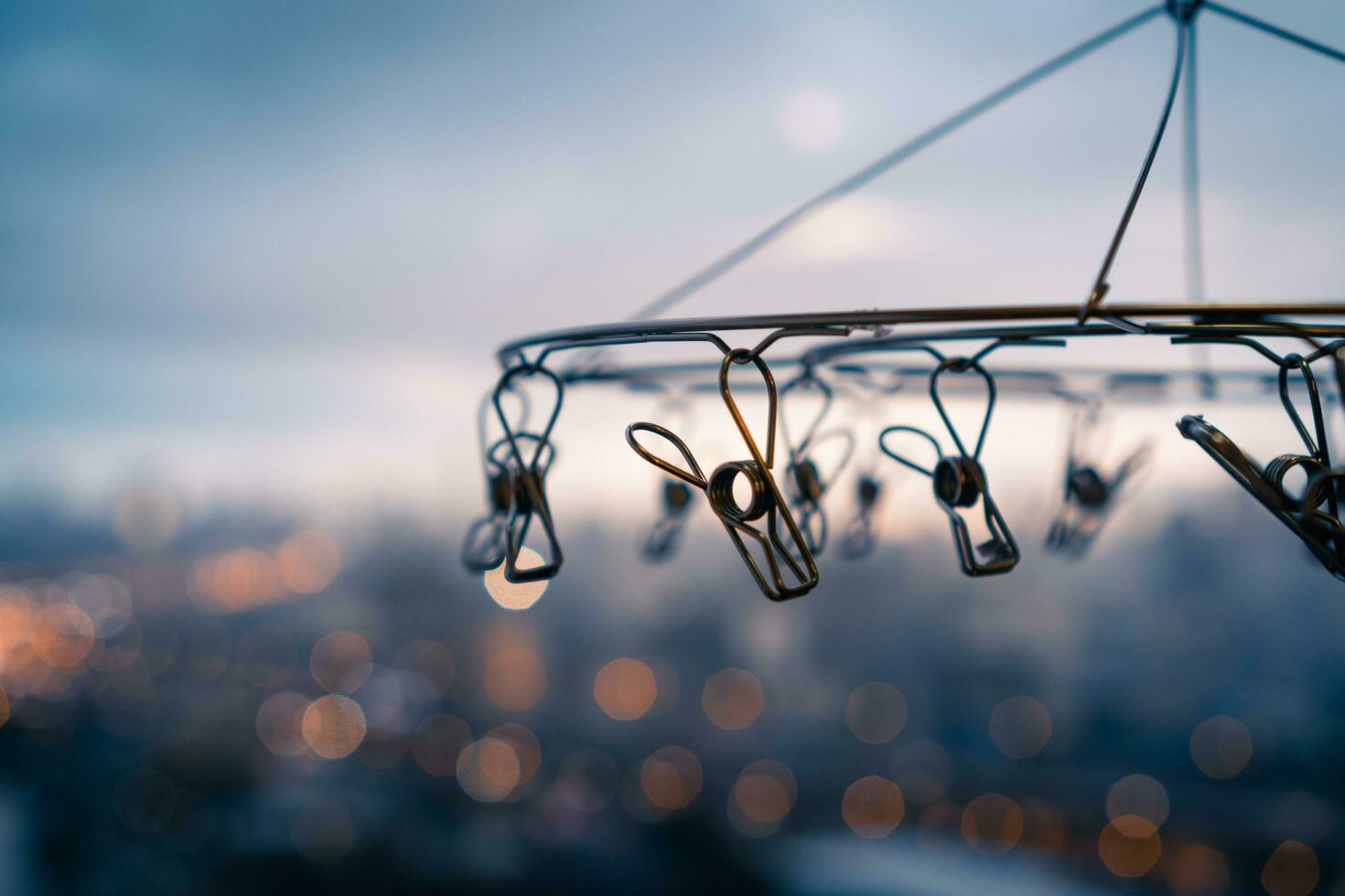 Close up of stainless steel hanging clothespins with blurred background of city in rainy day photo