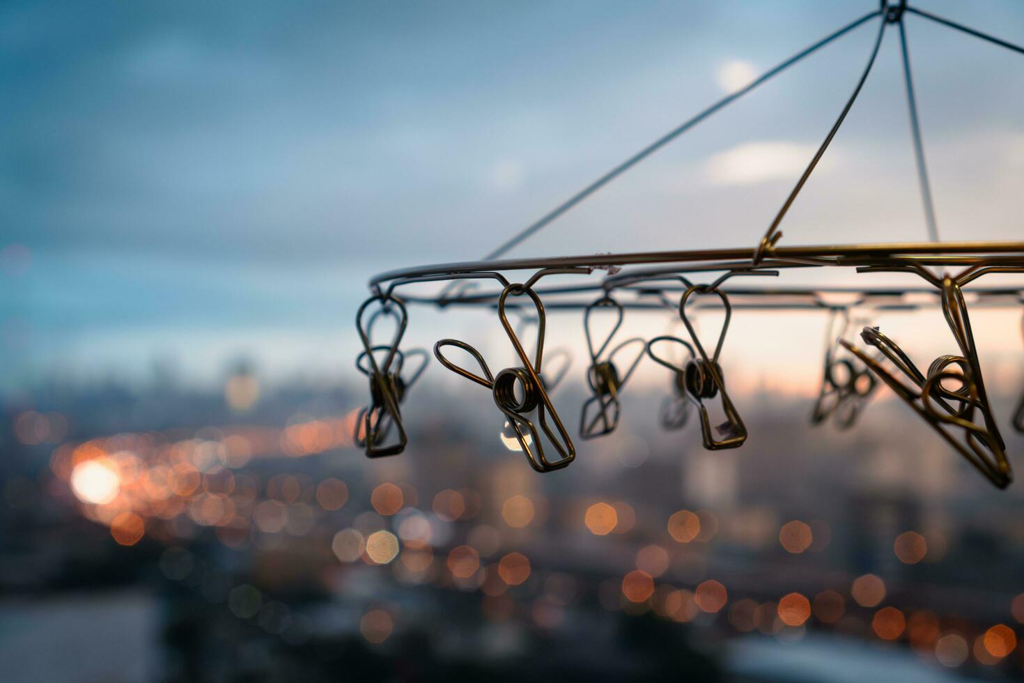 Close up of stainless steel hanging clothespins with blurred background of city in rainy day photo