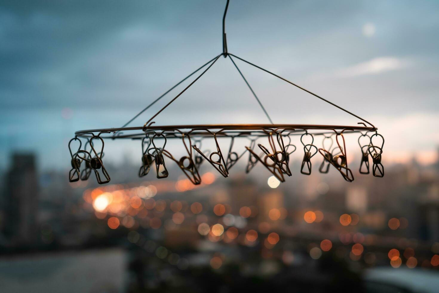 Close up of stainless steel hanging clothespins with blurred background of city in rainy day photo