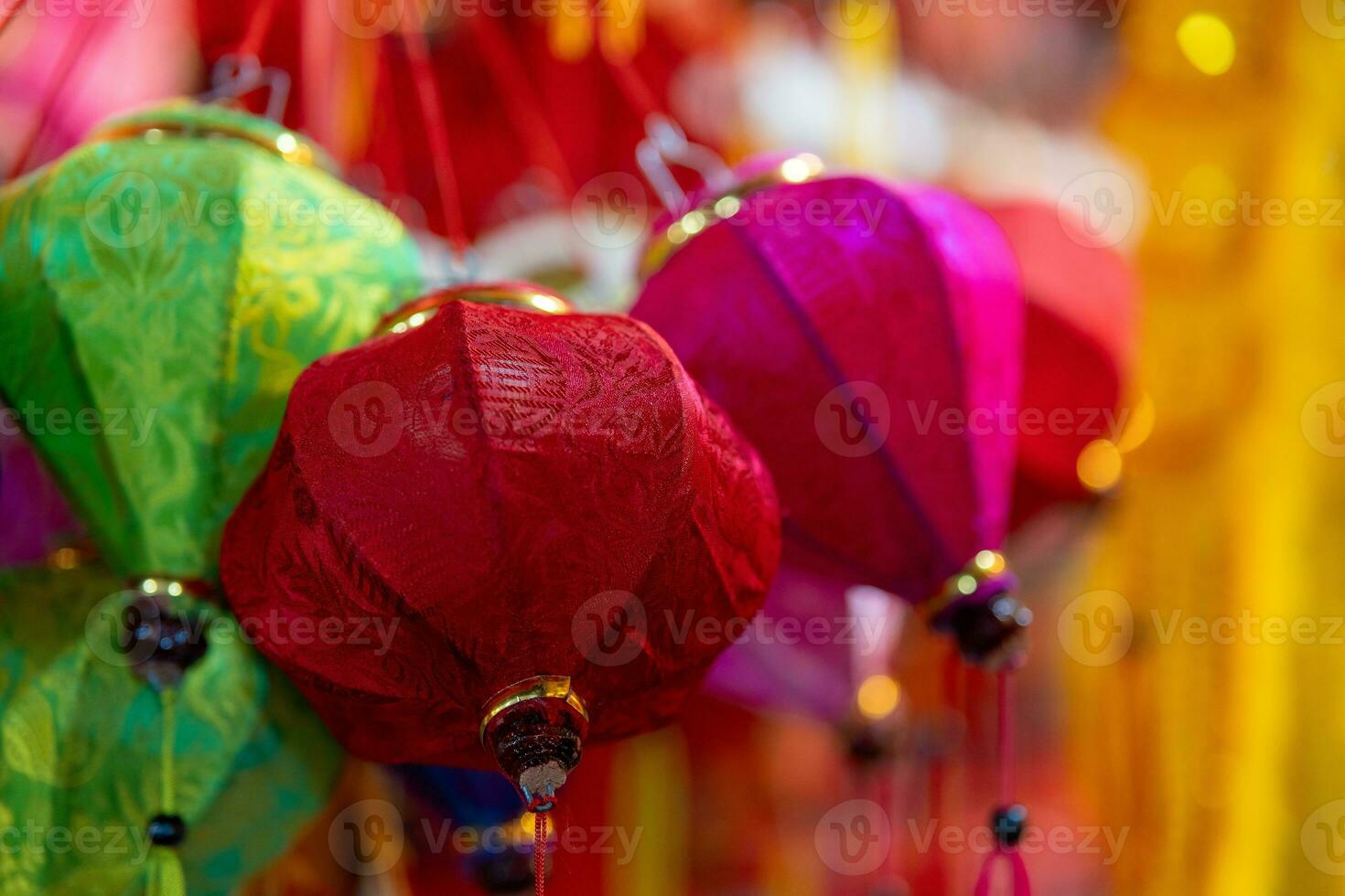 Decorated colorful lanterns hanging on a stand in the streets in Ho Chi Minh City, Vietnam during Mid Autumn Festival. Chinese language in photos mean money and happiness. Selective focus.