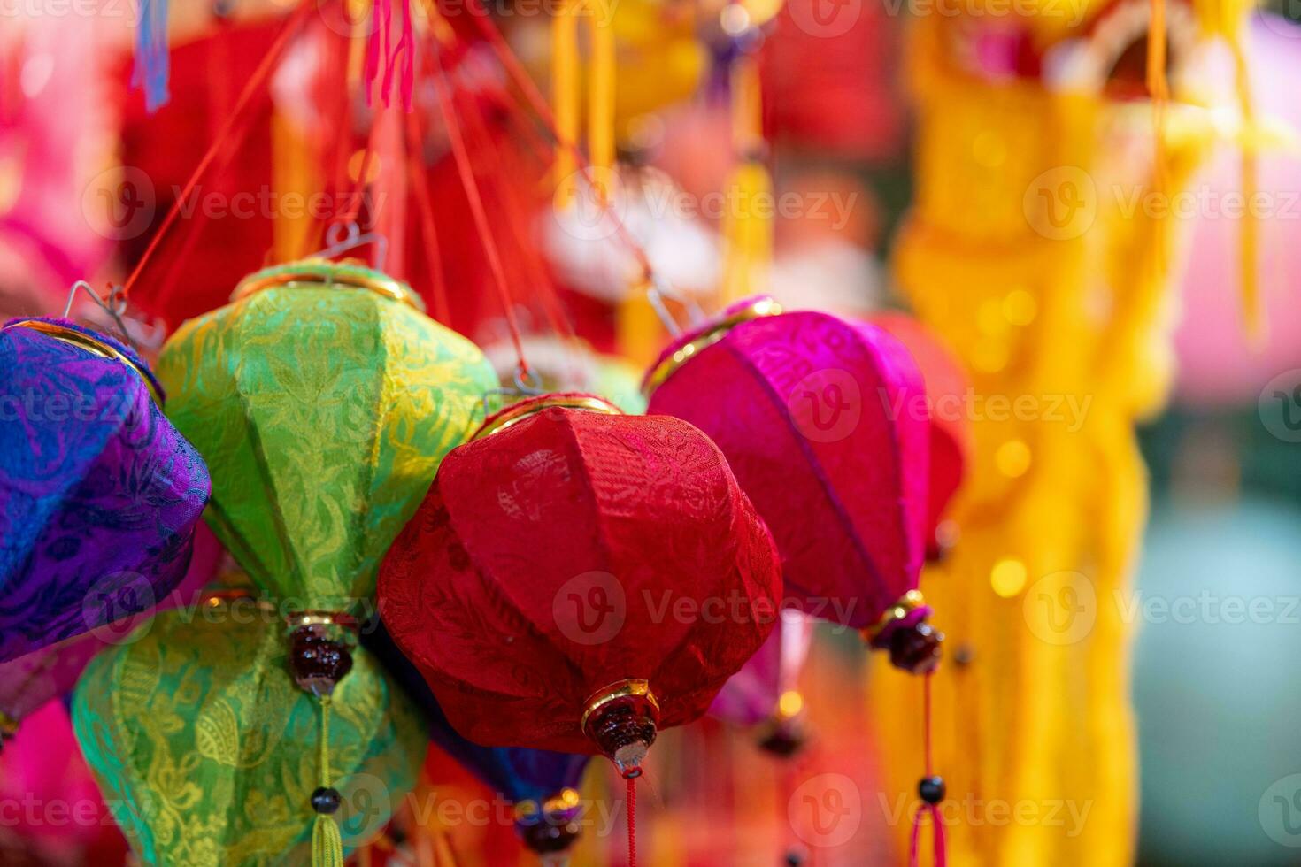 Decorated colorful lanterns hanging on a stand in the streets in Ho Chi Minh City, Vietnam during Mid Autumn Festival. Chinese language in photos mean money and happiness. Selective focus.