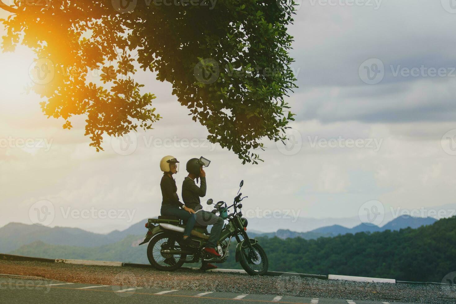 parejas vistiendo la seguridad casco sentado en pequeño enduro motocicleta en contra hermosa natural montaña escena a khaoyai nacional parque Tailandia foto
