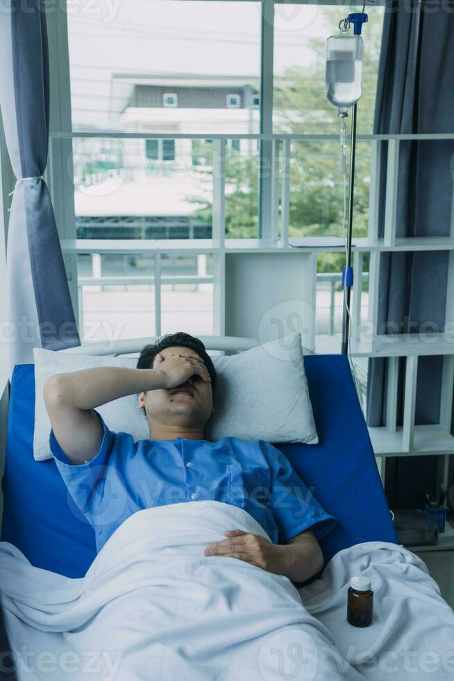 patient sat on the bed and looked out the window in the hospital alone and had stress, boredom, loneliness, anxiety photo