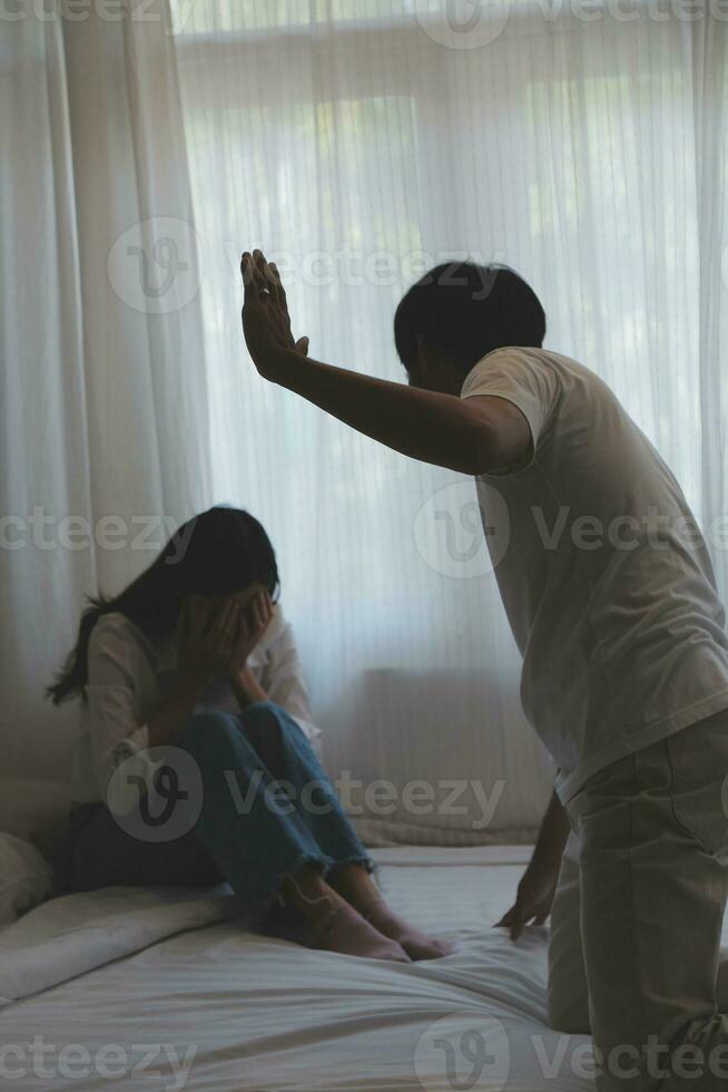 Upset woman having a fight with a man at home. Hispanic wife slapping the face of her husband during an argument because of their relationship problems photo