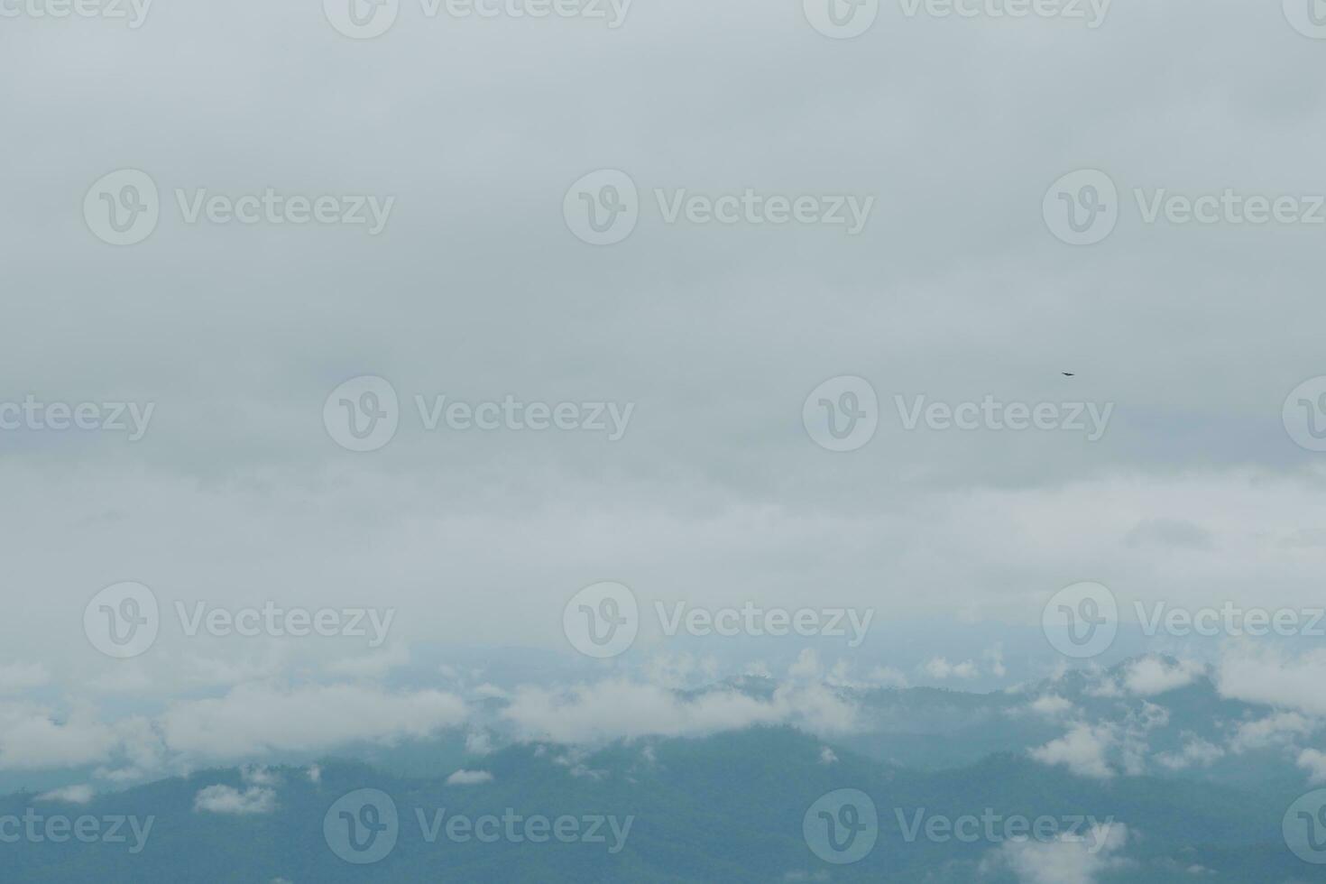 Beautiful panoramic view of fog and clouds in distant layers mountains range with blue sky in morning photo