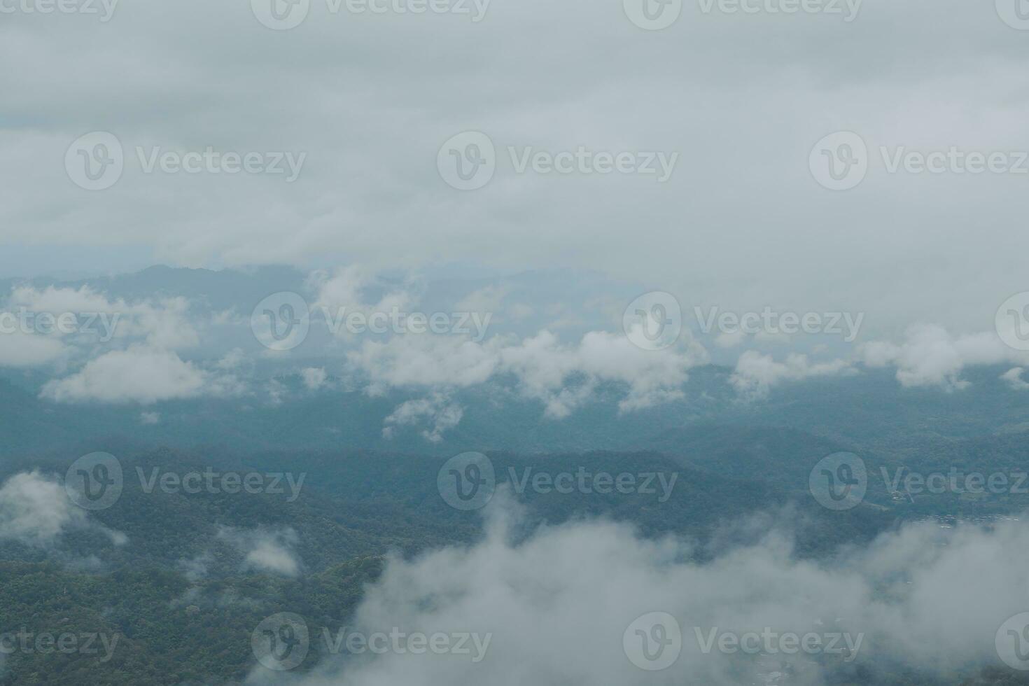 Beautiful panoramic view of fog and clouds in distant layers mountains range with blue sky in morning photo