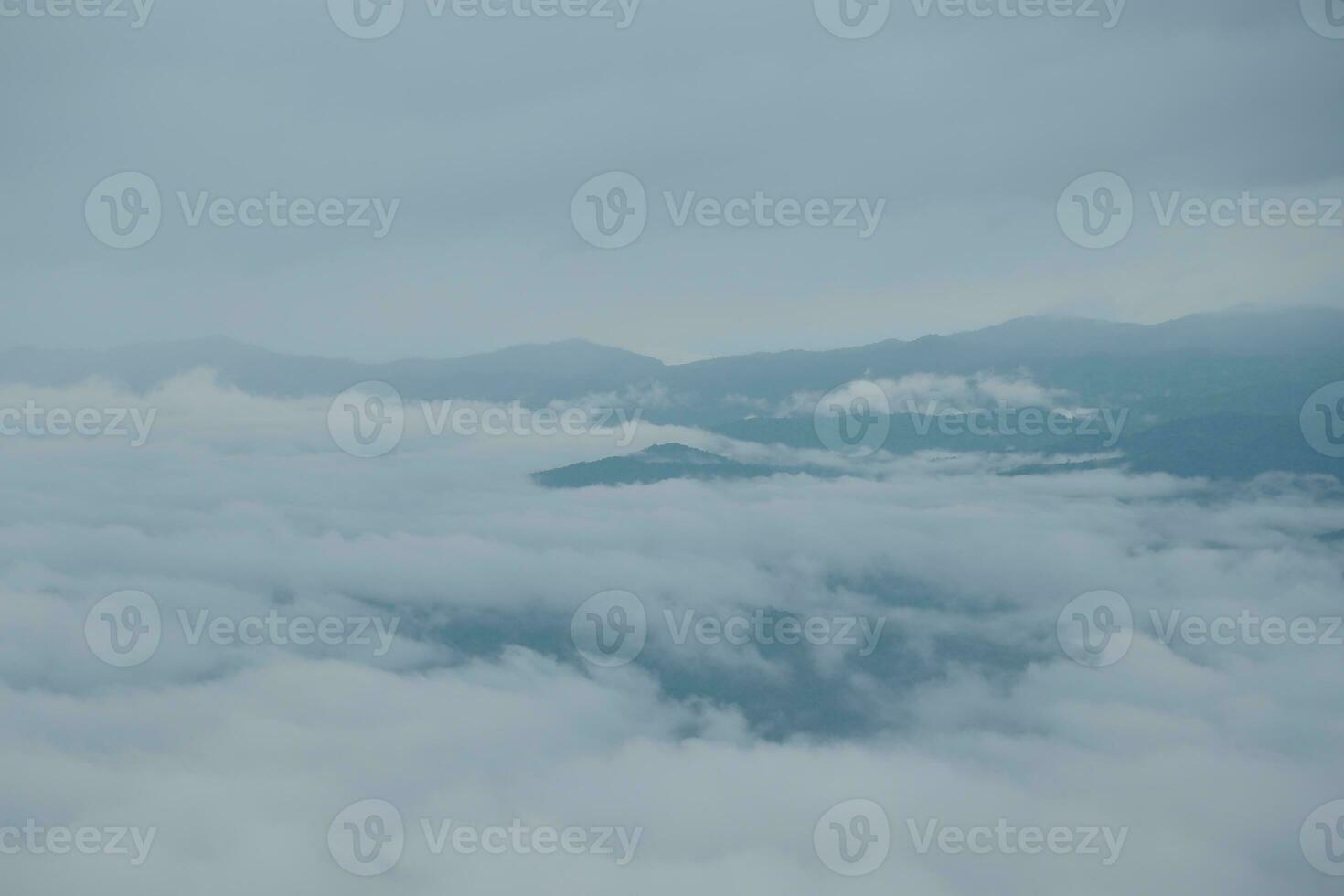 Mountain range with visible silhouettes through the morning blue fog. photo